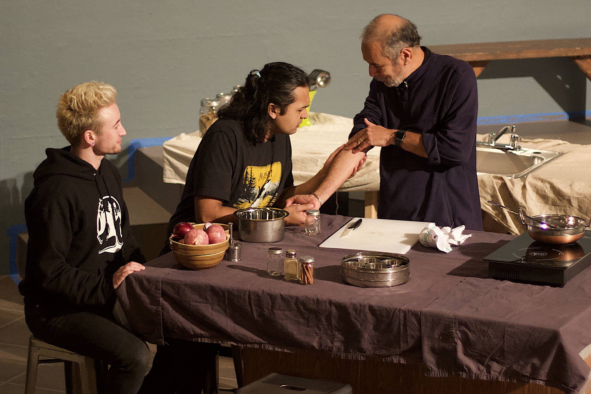 Jack Scholz, left, Tristan Cameron, center, and Dilip Ratnam discuss cultural upbringings in a rehearsal scene of “A Nice Indian Boy” at Perseverance Theatre on Tuesday night. The production is scheduled for the theater’s main stage from Dec. 1-17, with video on demand available Dec. 13-Jan. 22. (Mark Sabbatini / Juneau Empire)