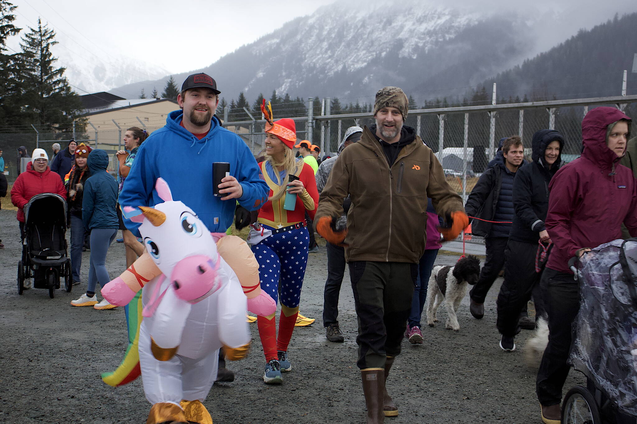 Participants, many clad in fowl weather gear, head out onto the Airport Dike Trail during the annual Turkey Trot 5K and 1 Mile Fun Run on Thursday morning. (Mark Sabbatini / Juneau Empire)