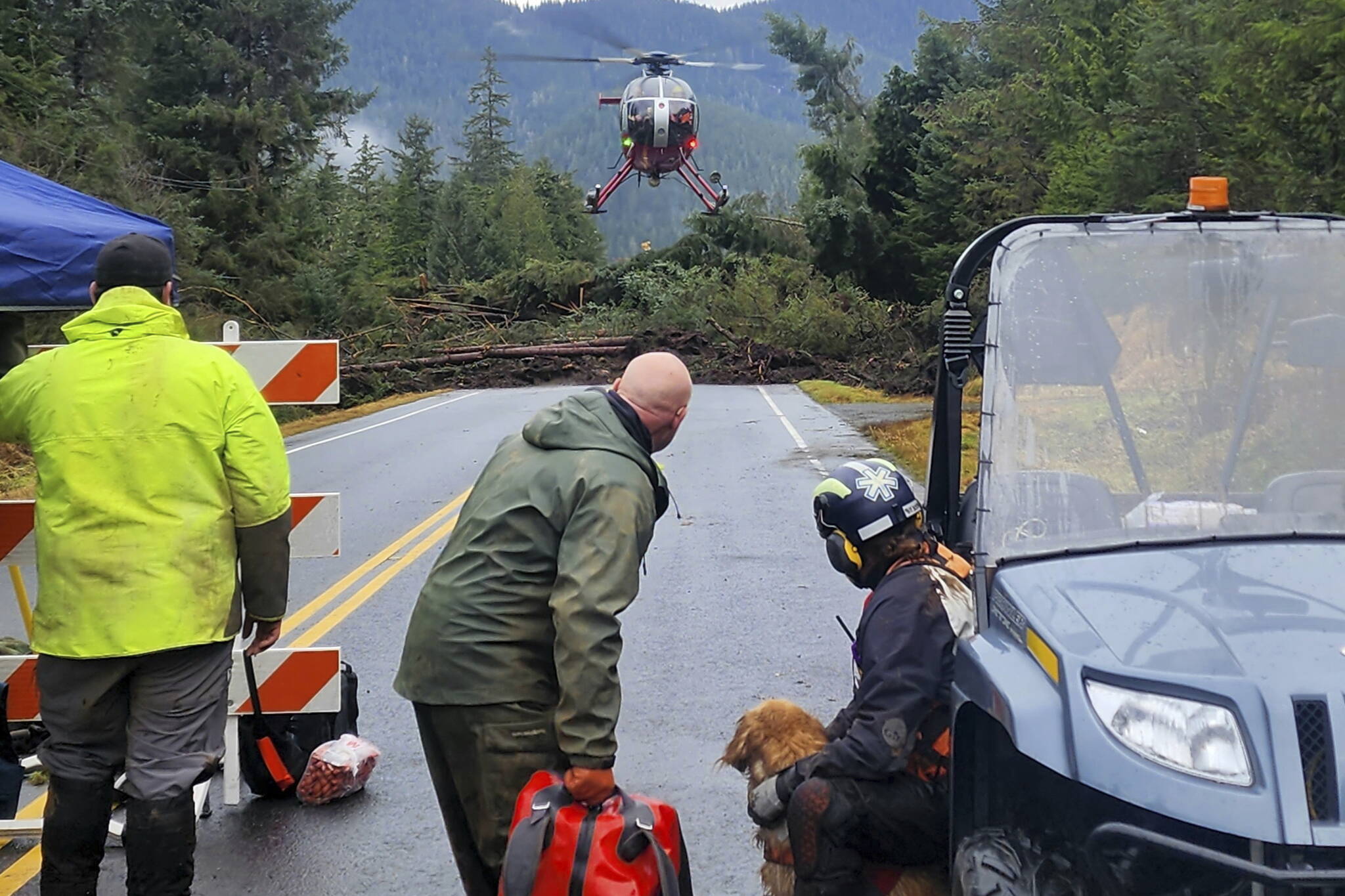 This photo provided by Division of Homeland Security and Emergency Management shows a helicopter arriving near mile 11 of the Zimovia Highway where ground teams, including search and rescue dogs, are actively working to search areas that state geologists have determined safe for entry Wednesday in Wrangell following a massive landslide earlier in the week. Three people have died and searchers looked Wednesday for three others who remain missing after a landslide ripped through a remote Alaska fishing community on Monday. (Willis Walunga/Division of Homeland Security and Emergency Management via AP)