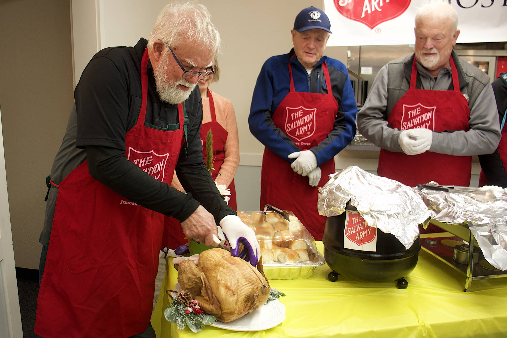 Jerry Harmon performs the ceremonial first carving of a turkey at The Salvation Army Juneau Corps’ annual communal Thanksgiving meal on Thursday at the Juneau Yacht Club. (Mark Sabbatini / Juneau Empire)