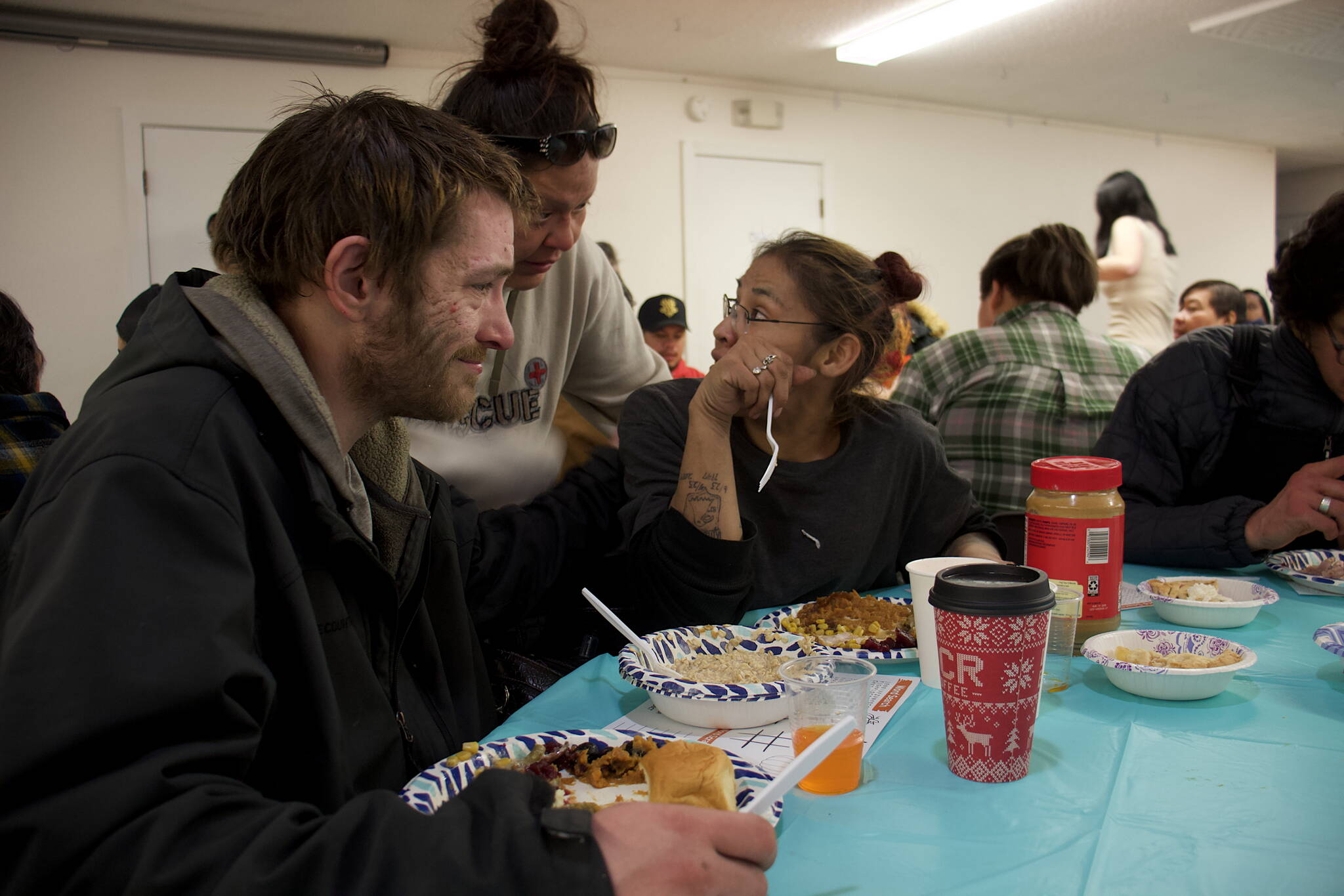 Mark Sabbatini / Juneau Empire
Christopher Whitehead and Ida Sheakley, at table, are visited by friend Shelly Stevens during a communal Thanksgiving meal at the Juneau Yacht Club hosted by The Salvation Army Juneau Corps on Thursday.