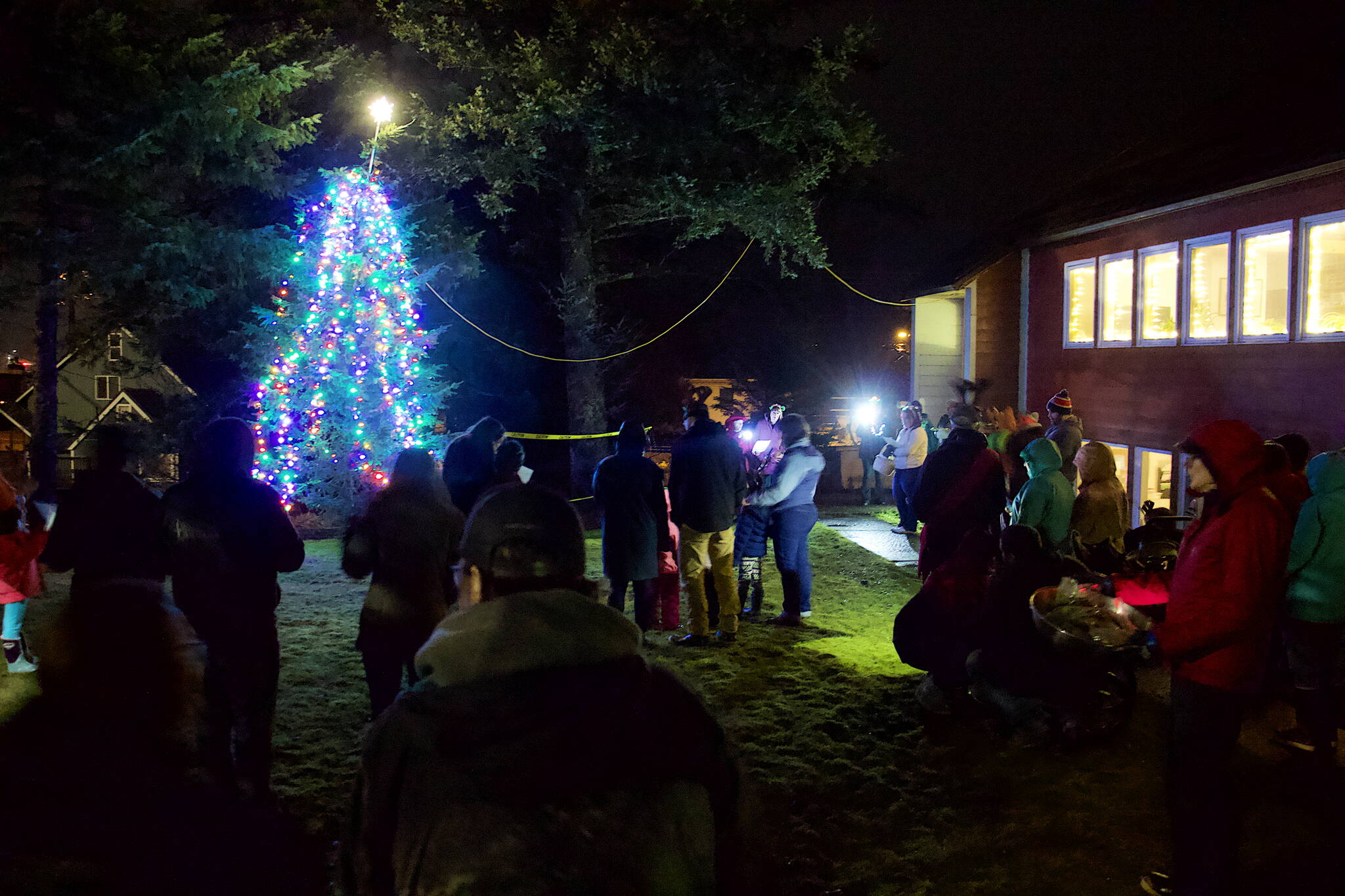 About 50 people watch the lighting of the Christmas tree outside Douglas Community United Methodist Church on Friday night. (Mark Sabbatini / Juneau Empire)