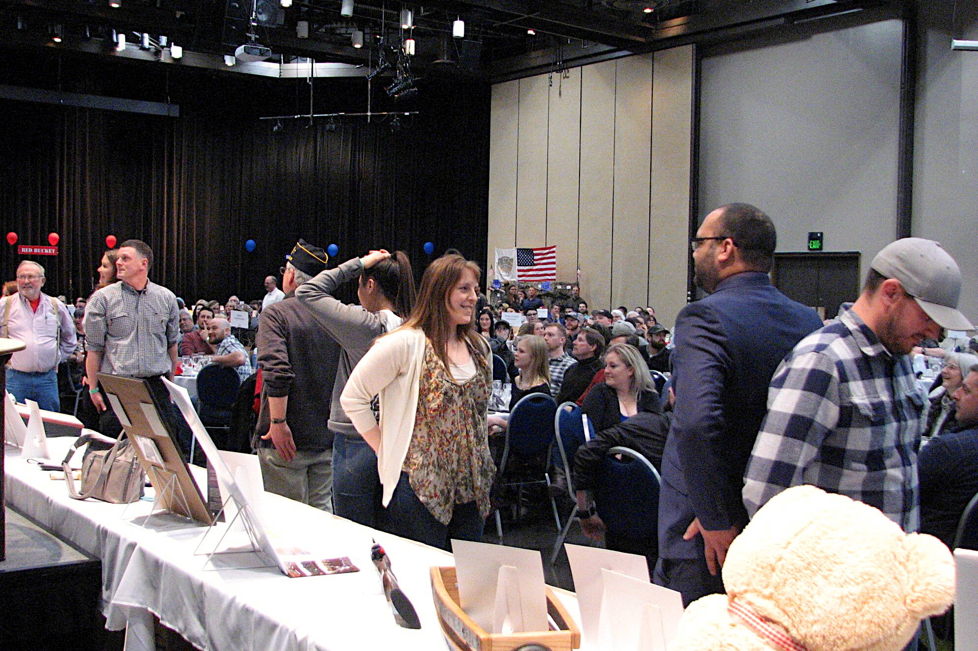 Attendees at the Friends of NRA — Juneau’s banquet in 2019 talk near auction tables at Centennial Hall. The fundraising event is resuming Saturday after a four-year COVID-19 disruption. (Photo courtesy of Friends of NRA — Juneau)