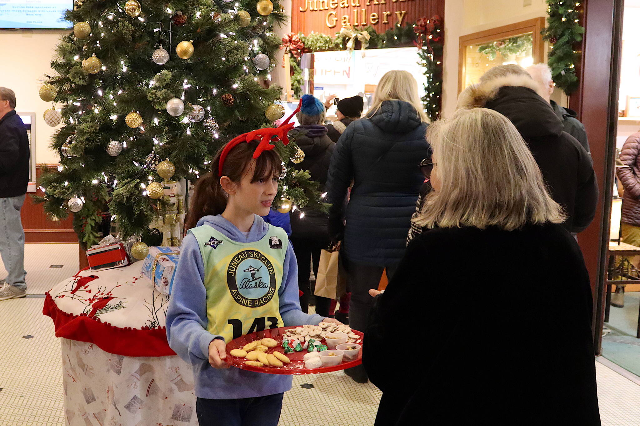 Audrey Burke, 10, offers cookies to people visiting shops at the Senate Building during Gallery Walk on Friday night. (Mark Sabbatini / Juneau Empire)