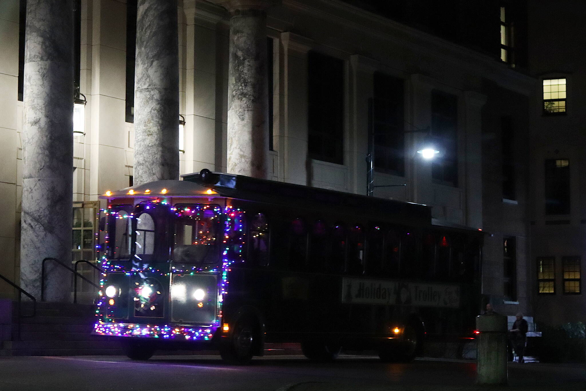The Holiday Trolley stops at the Alaska State Capitol, a new location on its circuit this year for activities inside the building and the adjacent Juneau-Douglas City Museum, during Gallery Walk on Friday night. (Mark Sabbatini / Juneau Empire)