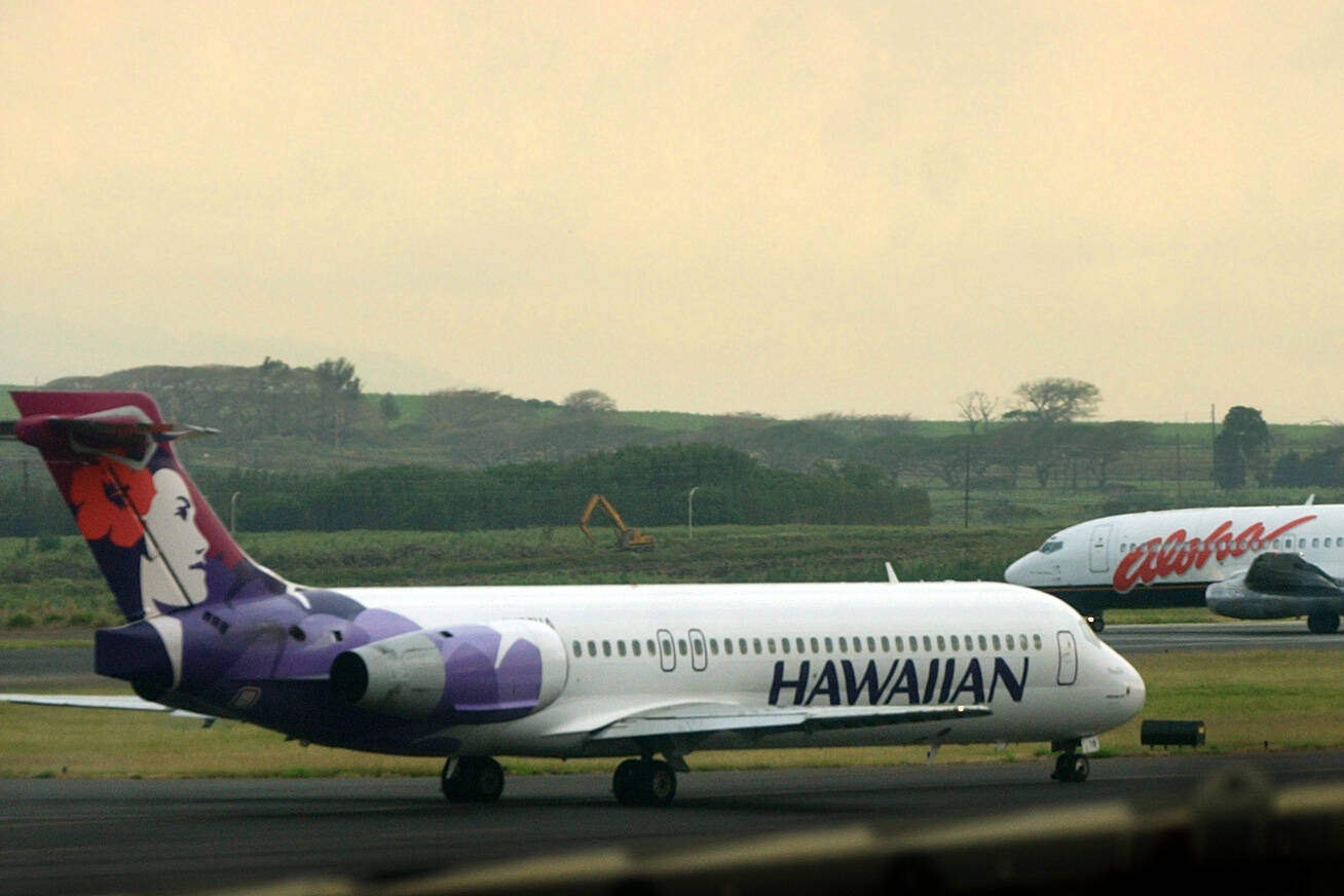 A Hawaiian Airlines plane taxis for position at Kahalui, Hawaii, on the island of Maui, March 24, 2005. Alaska Air Group said Sunday that it agreed to buy Hawaiian Airlines in a $1 billion deal. (AP Photo/Lucy Pemoni, File)