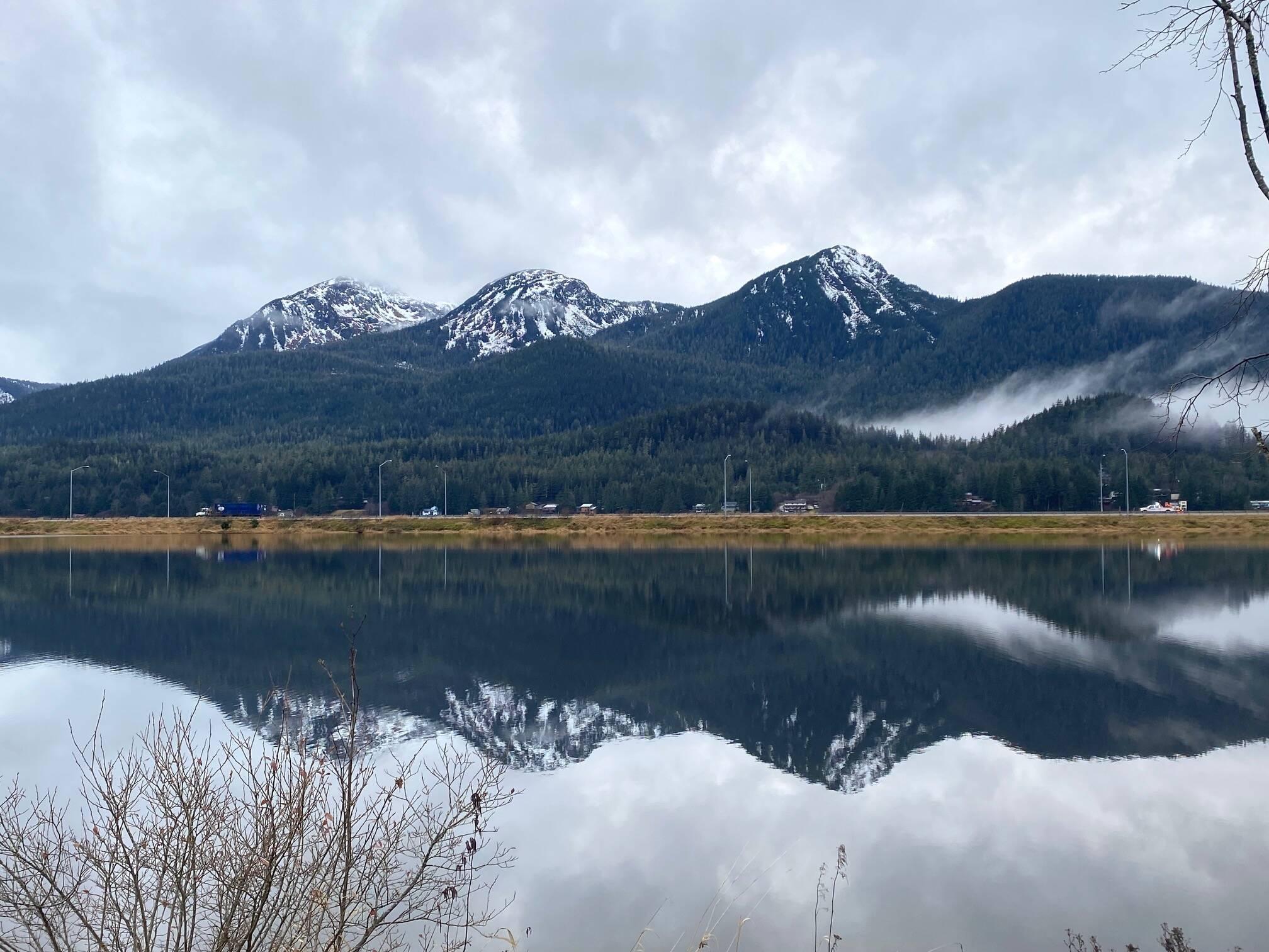 The three sisters — mountains Tabletop, Saddle and Anderson — reflect in Gastineau Channel on Nov. 27. (Photo by Denise Carroll)