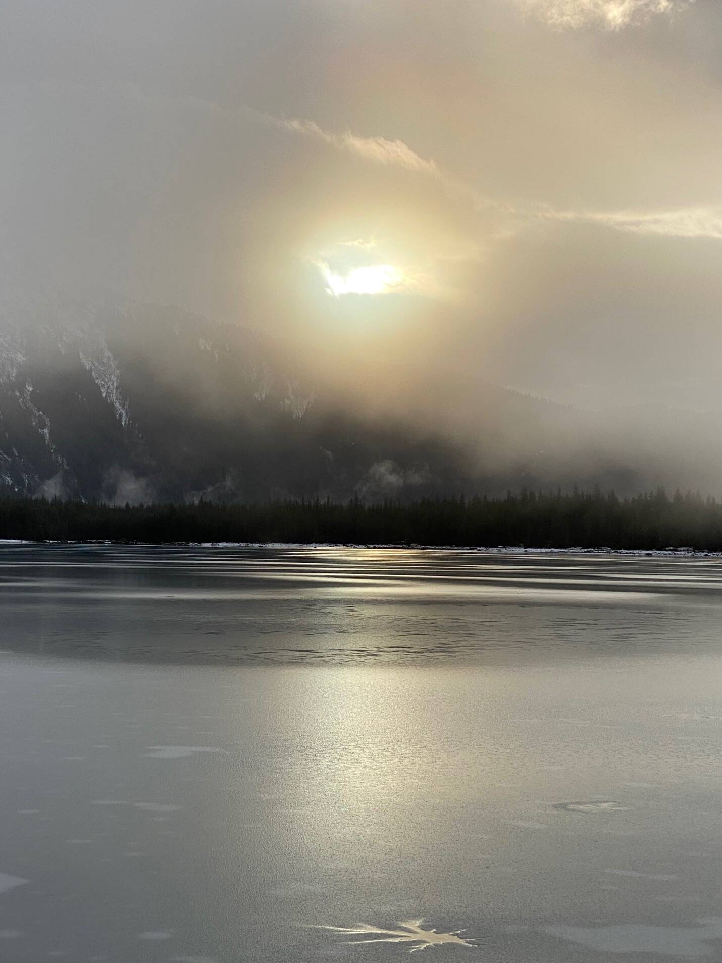Breaking through the clouds on a gray day, the sun makes a brief appearance shining across Mendenhall Lake on Nov. 22. (Photo by Denise Carroll)