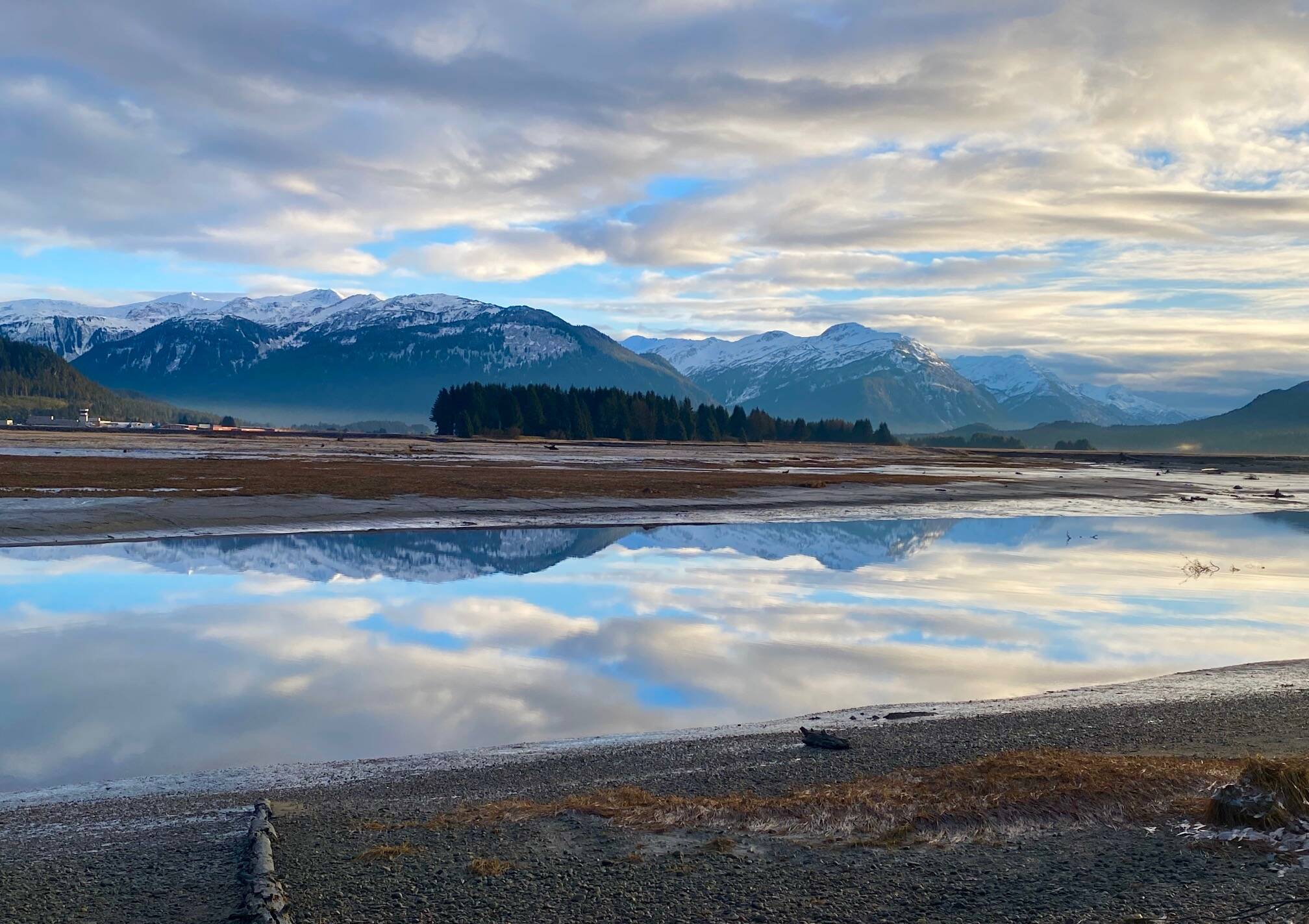 Cloud formations above Heinzelman Ridge and Mount Juneau reflect near the mouth of the Mendenhall River on Dec. 2. (Photo by Denise Carroll)
