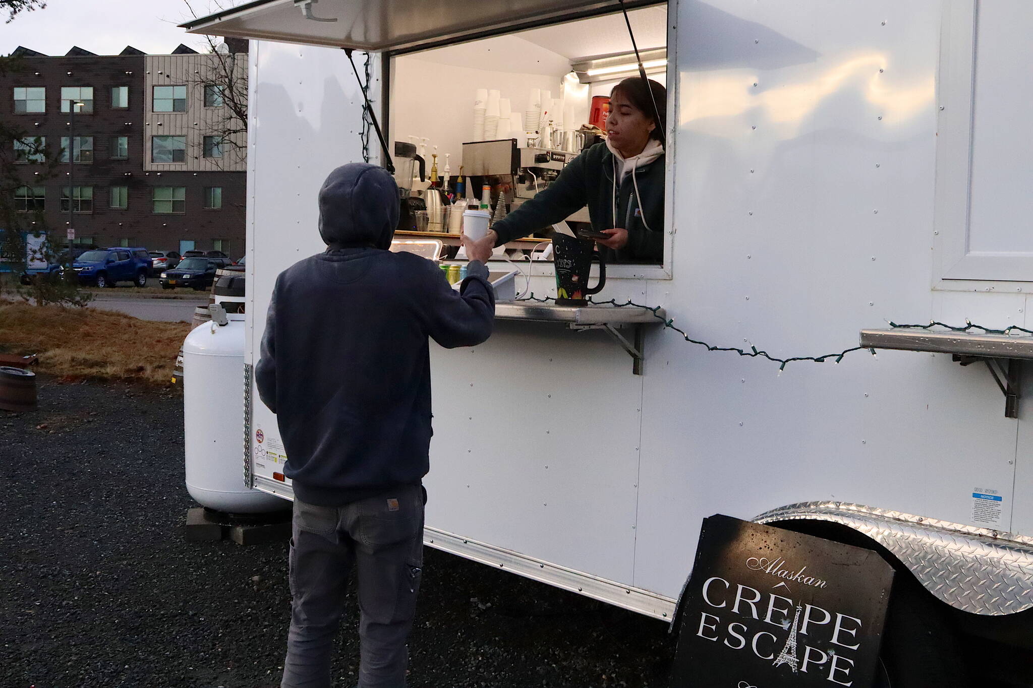 Larissa Dybdahl, an employee at the Crepe Escape food truck, hands a drunk to Brandon Elton at the new Vintage Food Truck Park on Wednesday. (Mark Sabbatini / Juneau Empire)
