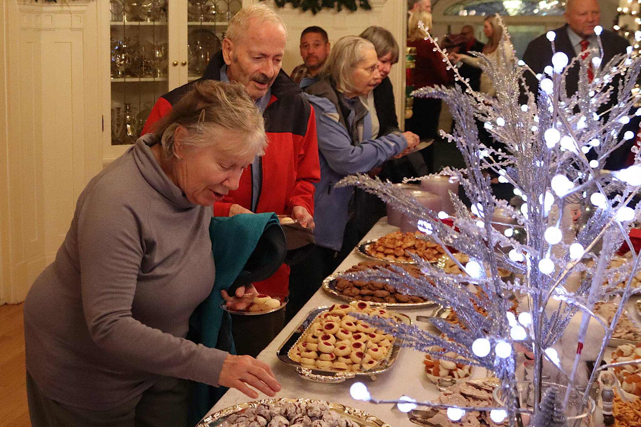 Julie and Richard Folta help themselves to some of the 21,350 cookies prepared for the annual Holiday Open House at the Governor’s Residence on Tuesday. Richard Folta said his first visit to an open house hosted by the governor occurred many years before Alaska became a state in 1959. (Mark Sabbatini / Juneau Empire)