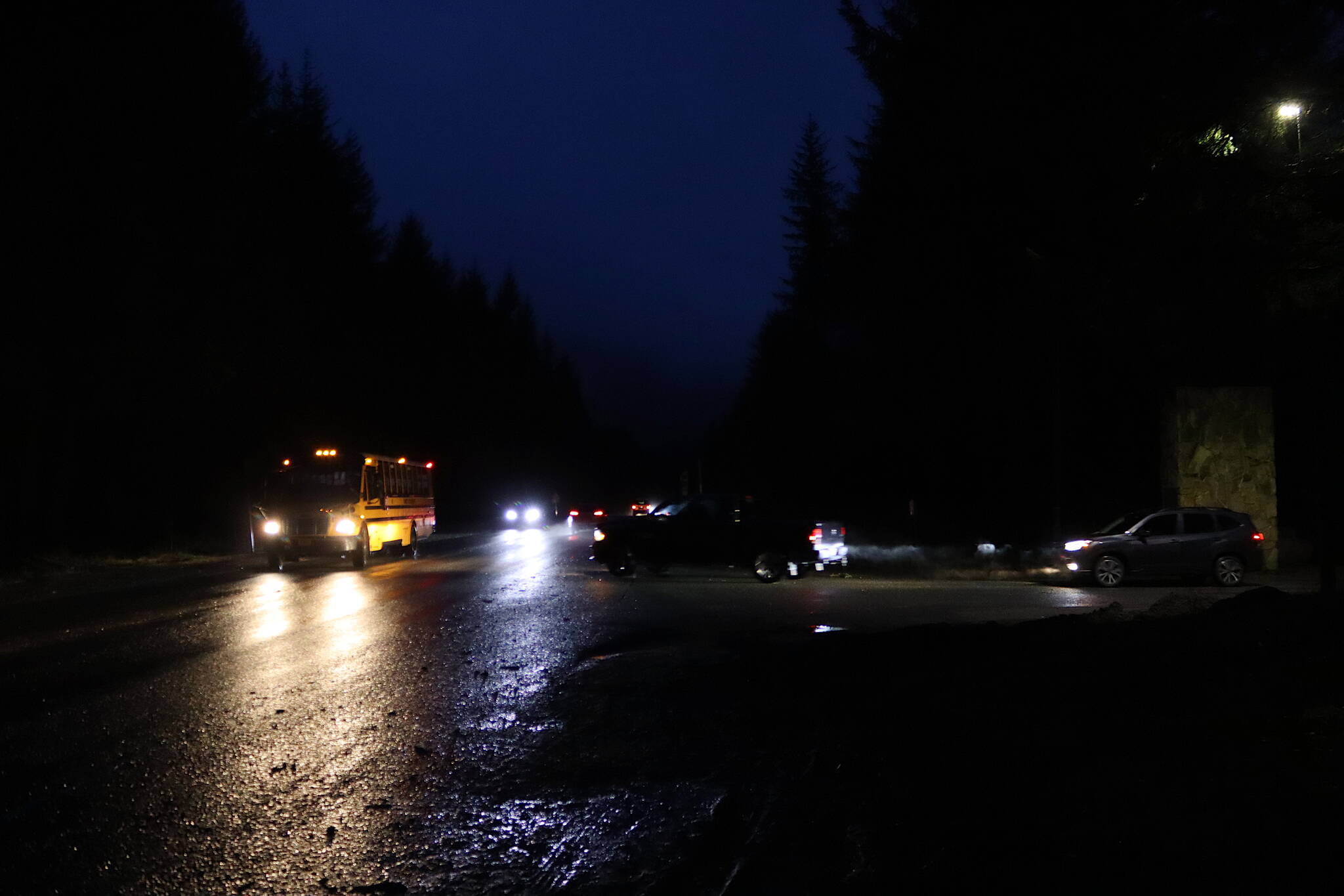 A school bus on Back Loop Road prepares to turn into the entrance to Mendenhall River Community School shortly before classes start on Wednesday morning. Juneau School District Superintendent Frank Hauser on Tuesday said he is asking state transportation officials to consider street lights and/or other safety improvements on the road following a collision last Thursday between a vehicle and three people walking to the school. (Mark Sabbatini / Juneau Empire)