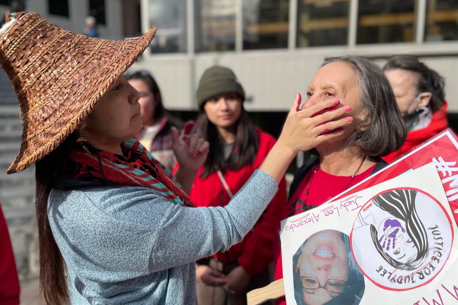 Candace Frank gets a red handprint pressed onto her face at the Missing and Murdered Indigenous People Rally in Juneau on May 5, 2022. (Lisa Phu / Alaska Beacon)