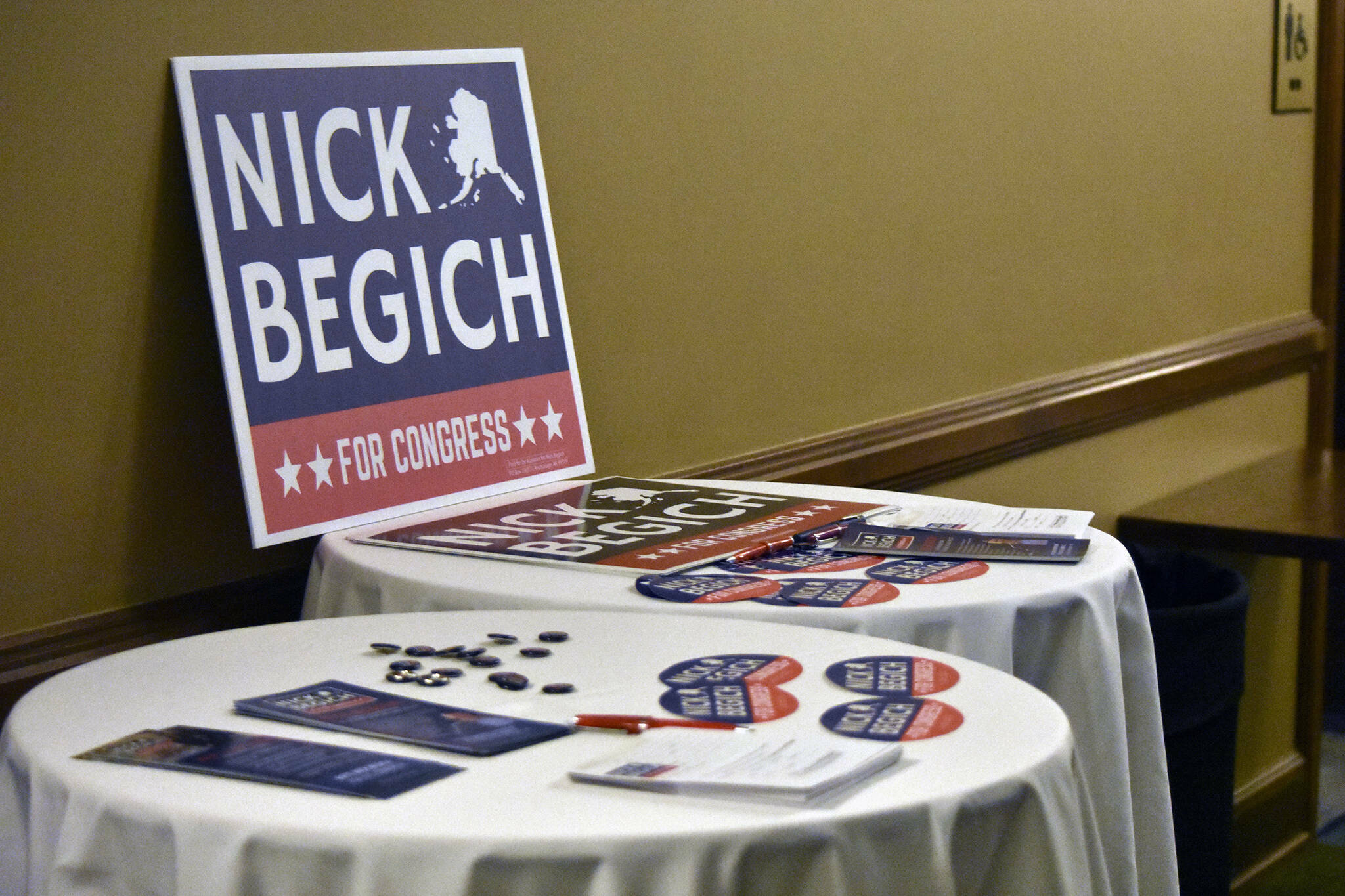 Nick Begich III campaign materials sit on tables ahead of a May 16, 2022, GOP debate held in Juneau. (Peter Segall / Juneau Empire file photo)