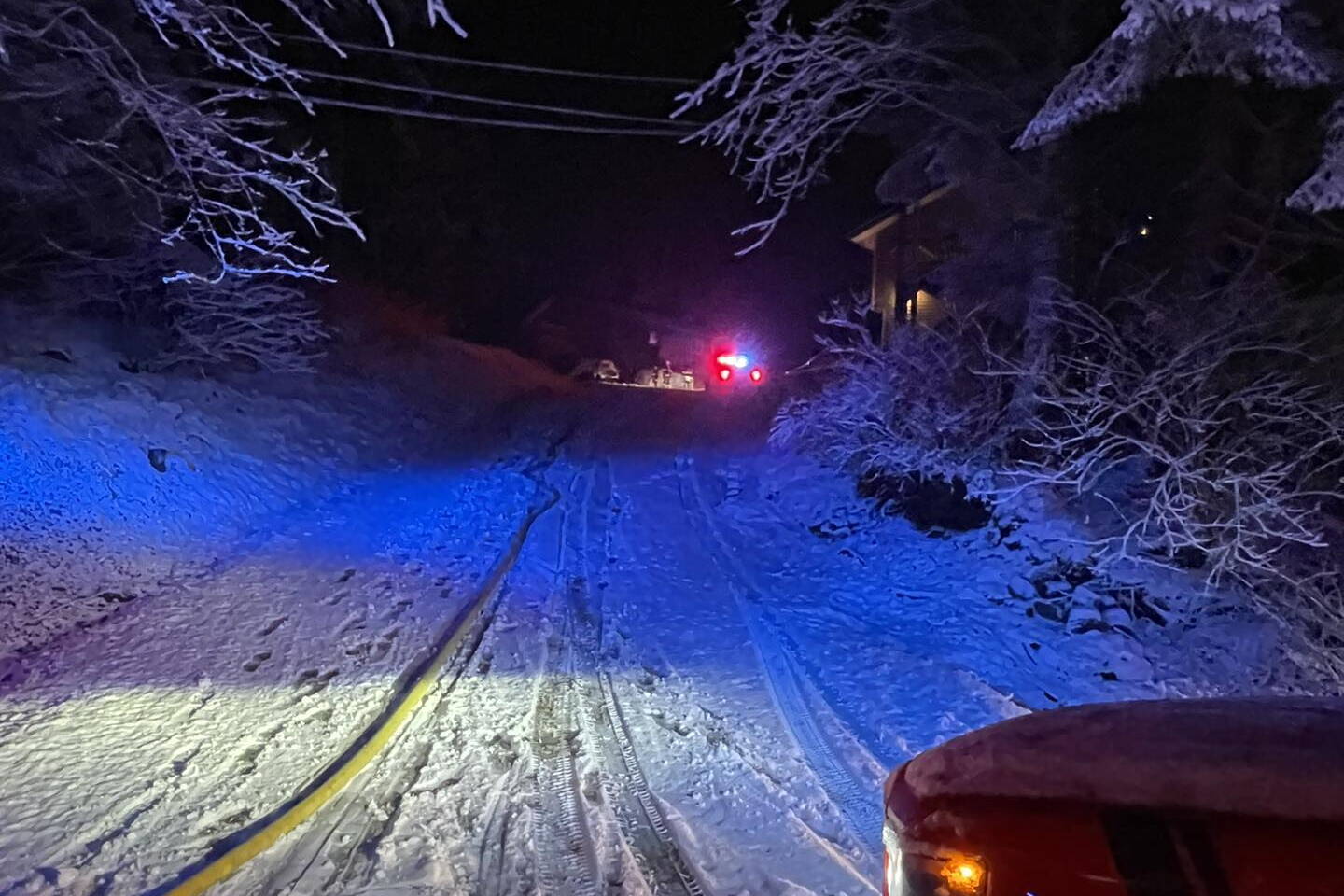 A fire hose lies along an uphill driveway to a residence in the 15000 block of Glacier Highway that caught fire early Thursday morning. Firefighters were forced to pull the hose about 100 yards up the driveway to the home because the fire truck was unable to access it due to slippery conditions. (Photo by Capital City Fire/Rescue)