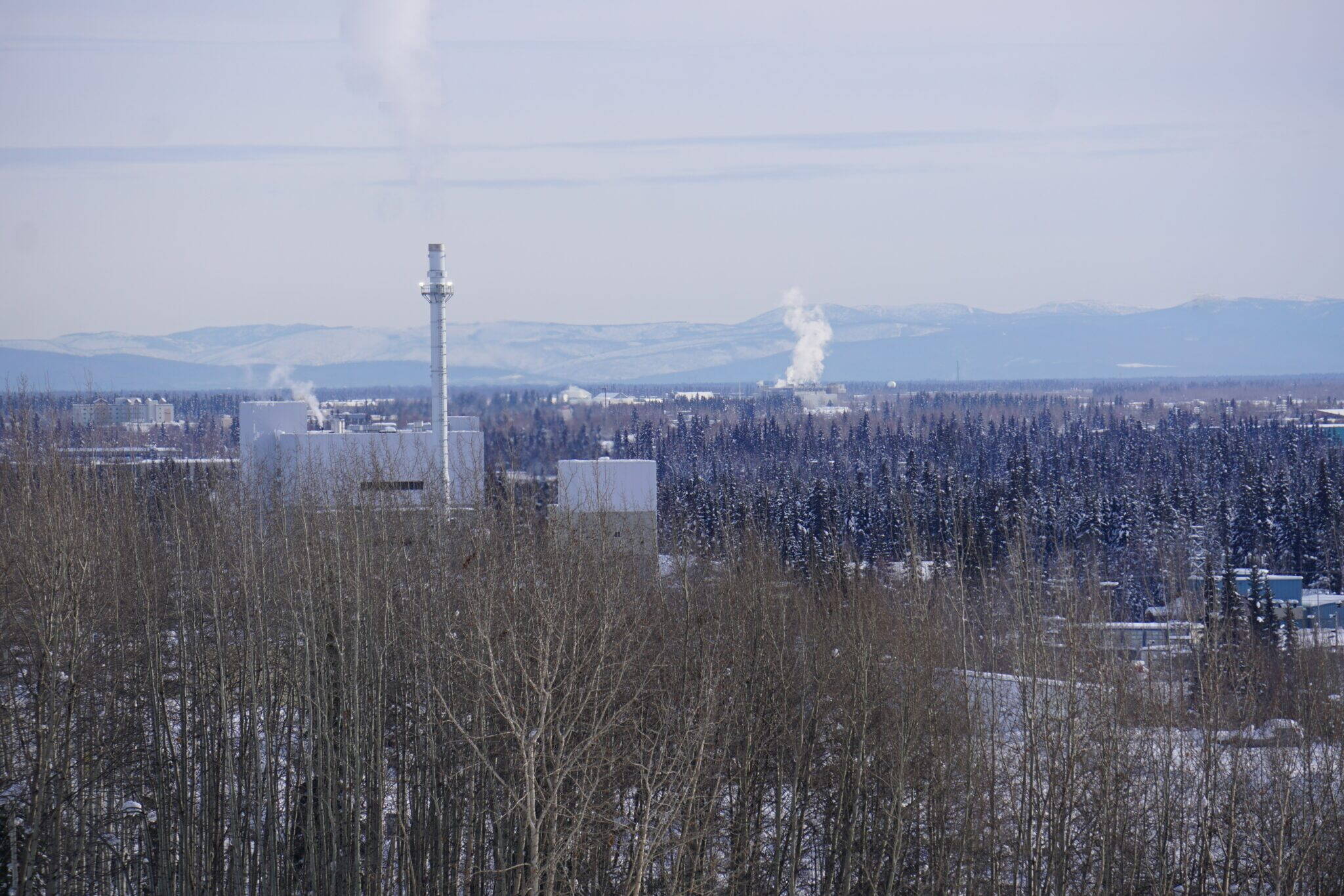 Smokestack emissions are seen along the Fairbanks skyline on March 1, 2023. At left is the coal-fired heat and power plant on the University of Alaska Fairbanks campus. (Yereth Rosen/Alaska Beacon)