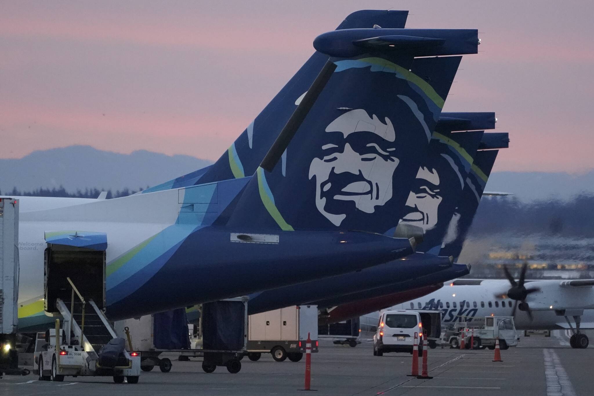 Alaska Airlines planes are shown parked at gates at sunrise, March 1, 2021, at Seattle-Tacoma International Airport in Seattle. An Alaska Airlines flight made an emergency landing in Oregon on Friday after a window and chunk of its fuselage blew out in mid-air, media reports said. (AP Photo/Ted S. Warren, File)