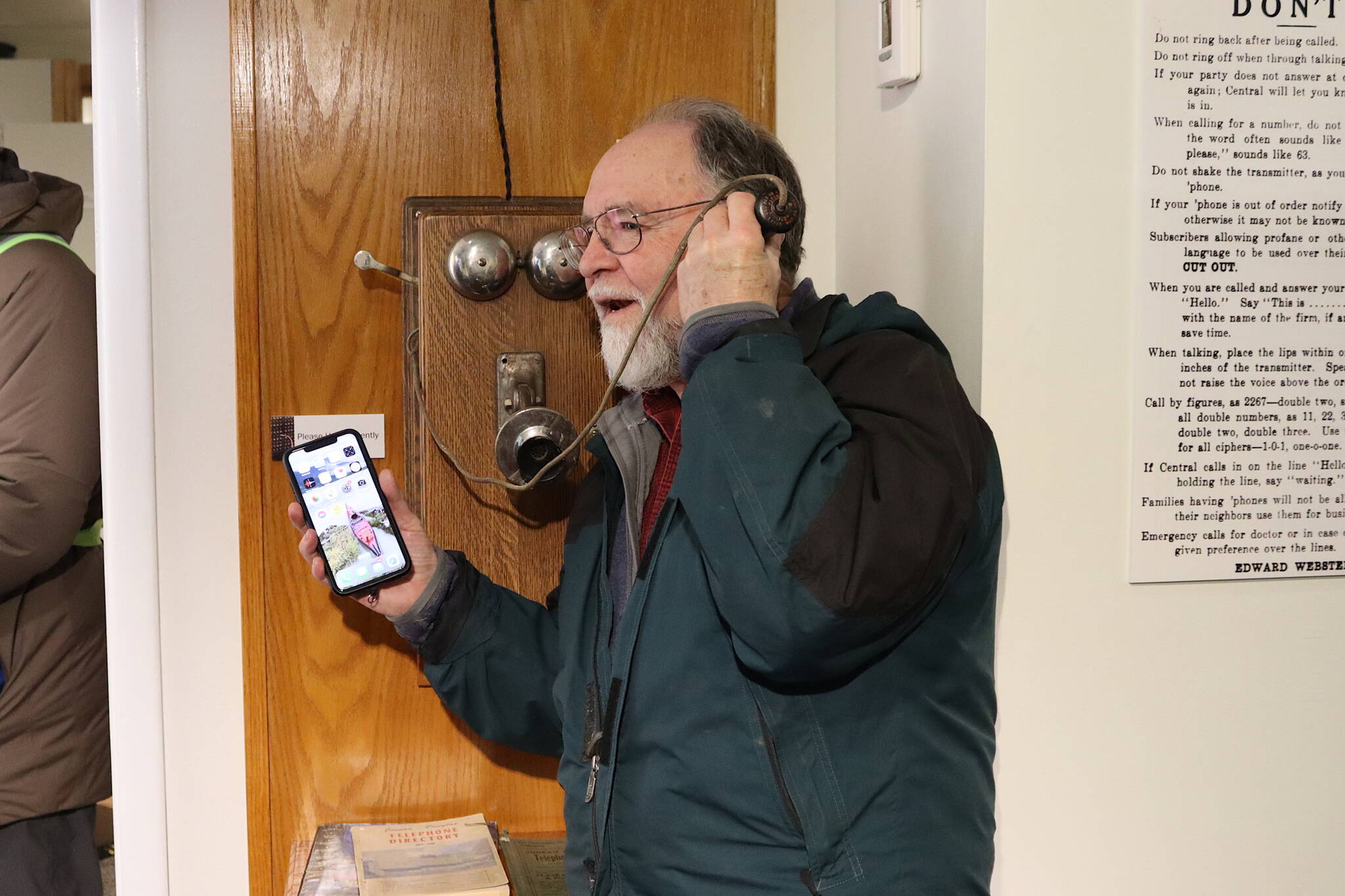Skip Gray holds a simulated conversation on an early 20th-century box phone and his cell phone during the opening of the exhibit “Switch and Exchange: A Brief History of Telephones in 20th Century Juneau” at the Juneau-Douglas City Museum on Friday. Gray is a former resident of the Telephone Hill neighborhood, which got its name when Juneau became the first city in Alaska with an established telephone system and a telephone company called the downtown area home during the early 1900s. (Mark Sabbatini / Juneau Empire)