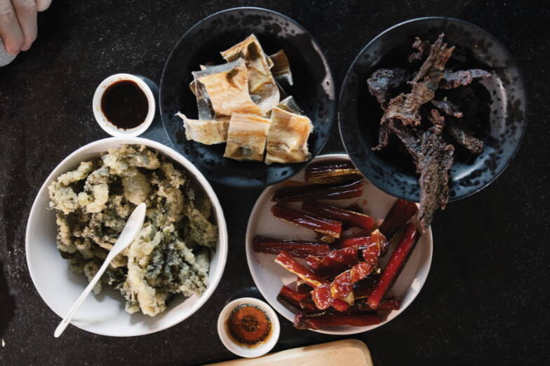 Traditional foods, including herring eggs on kelp, dried pike, smoked salmon, seal oil and dried moose meat, prepared for Dillingham community members and supporters of the Smokehouse Collective, an Alaska Native mutual aid network. (Photo by Emily Sullivan/High Country News)