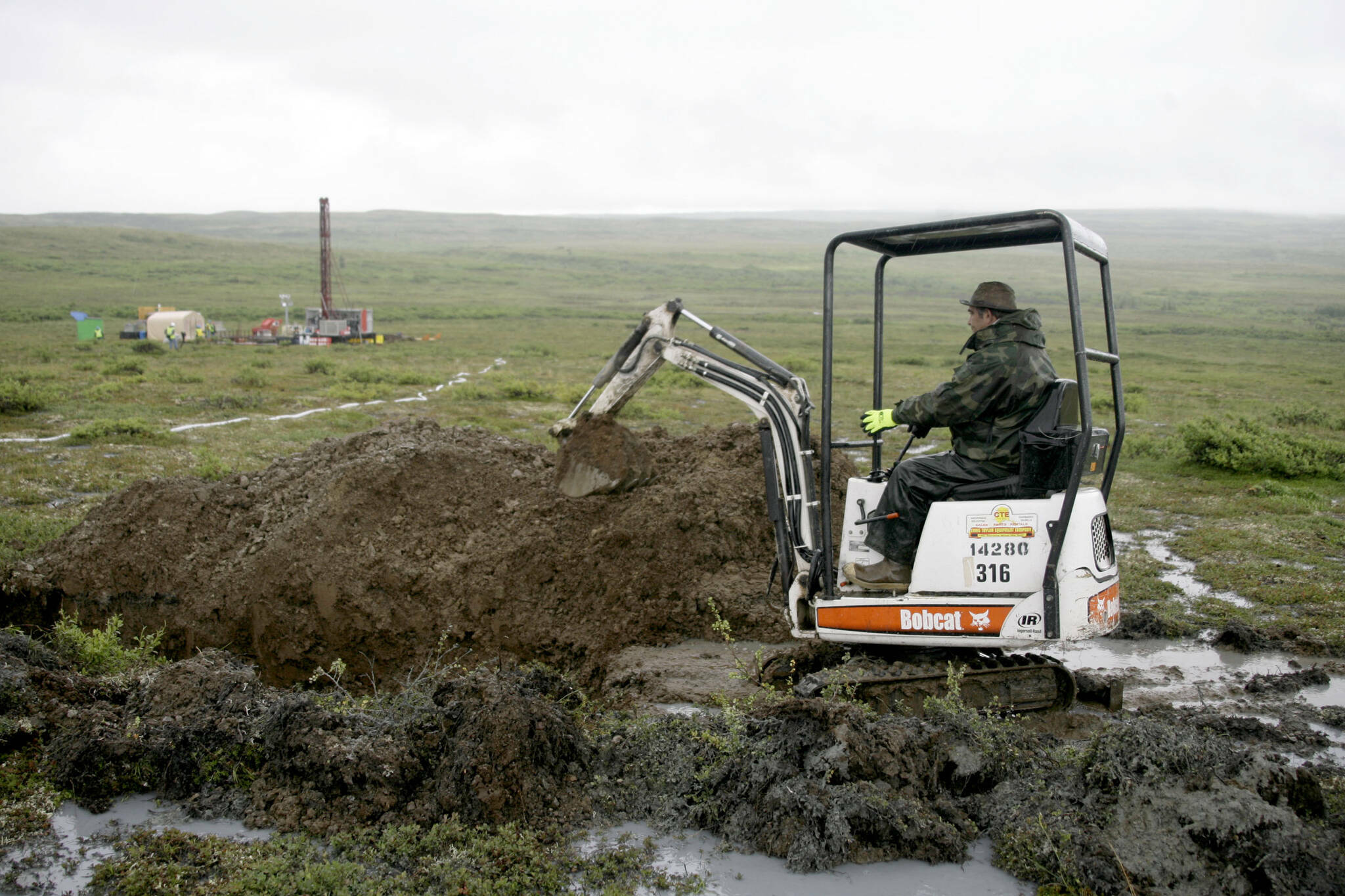 A worker with the Pebble Mine project digs in the Bristol Bay region of Alaska near the village of Iliamma, Alaska, July 13, 2007. (AP Photo / Al Grillo)