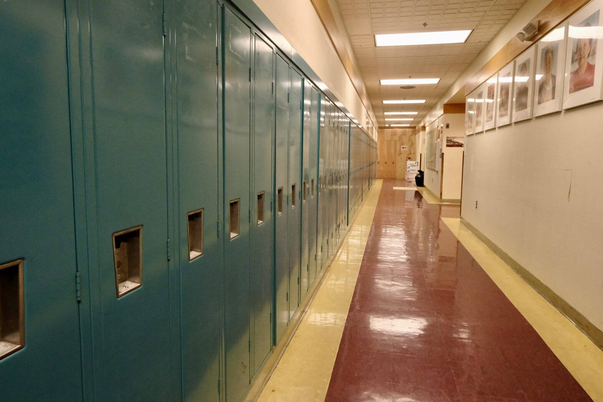 The halls are lined with lockers and portraits of elders at the Anna Tobeluk Memorial School in Nunapitchuk on Oct. 12, 2023. (Photo by Claire Stremple/Alaska Beacon)