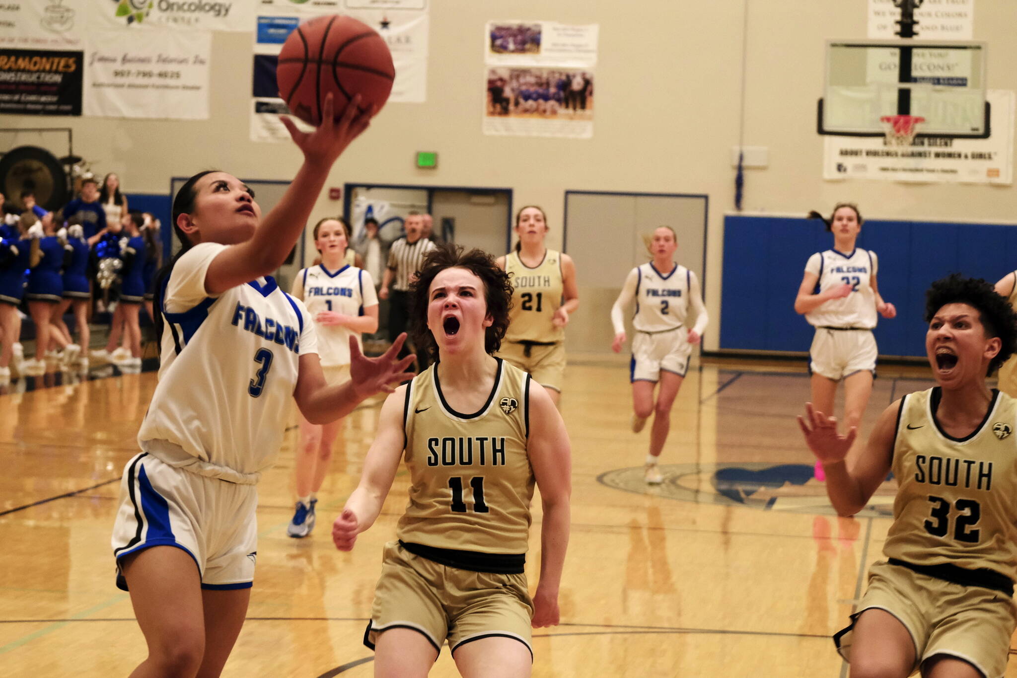 Thunder Mountain senior Jaya Carandang (3) scores past South Anchorage defenders Reese Gebauer (11) and Isa Costadasily (32) during the Falcons 73-37 win over the Wolverines on Thursday at the Thunderdome. (Klas Stolpe / For the Juneau Empire)