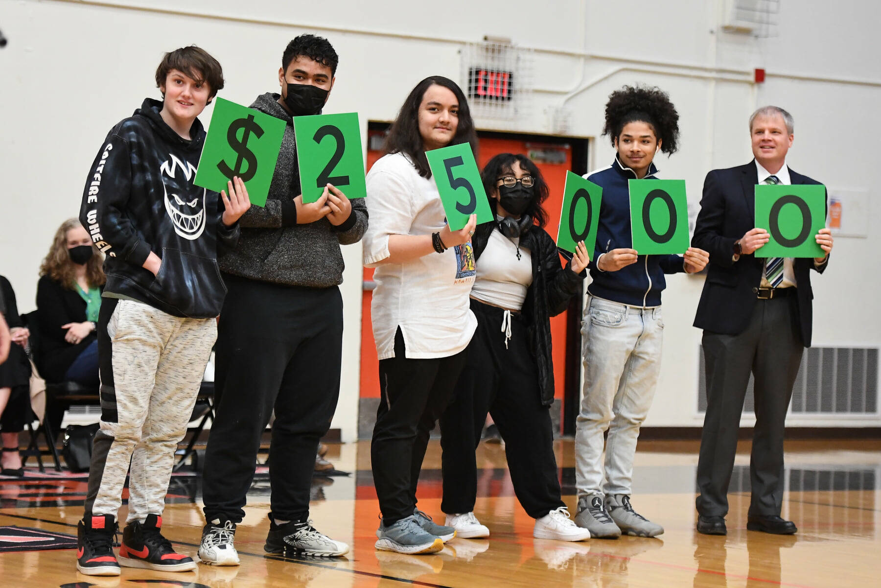 Alaska students hold up numbers representing the amount of an educator award presented in 2022. (Alaska Department of Education and Early Development photo)