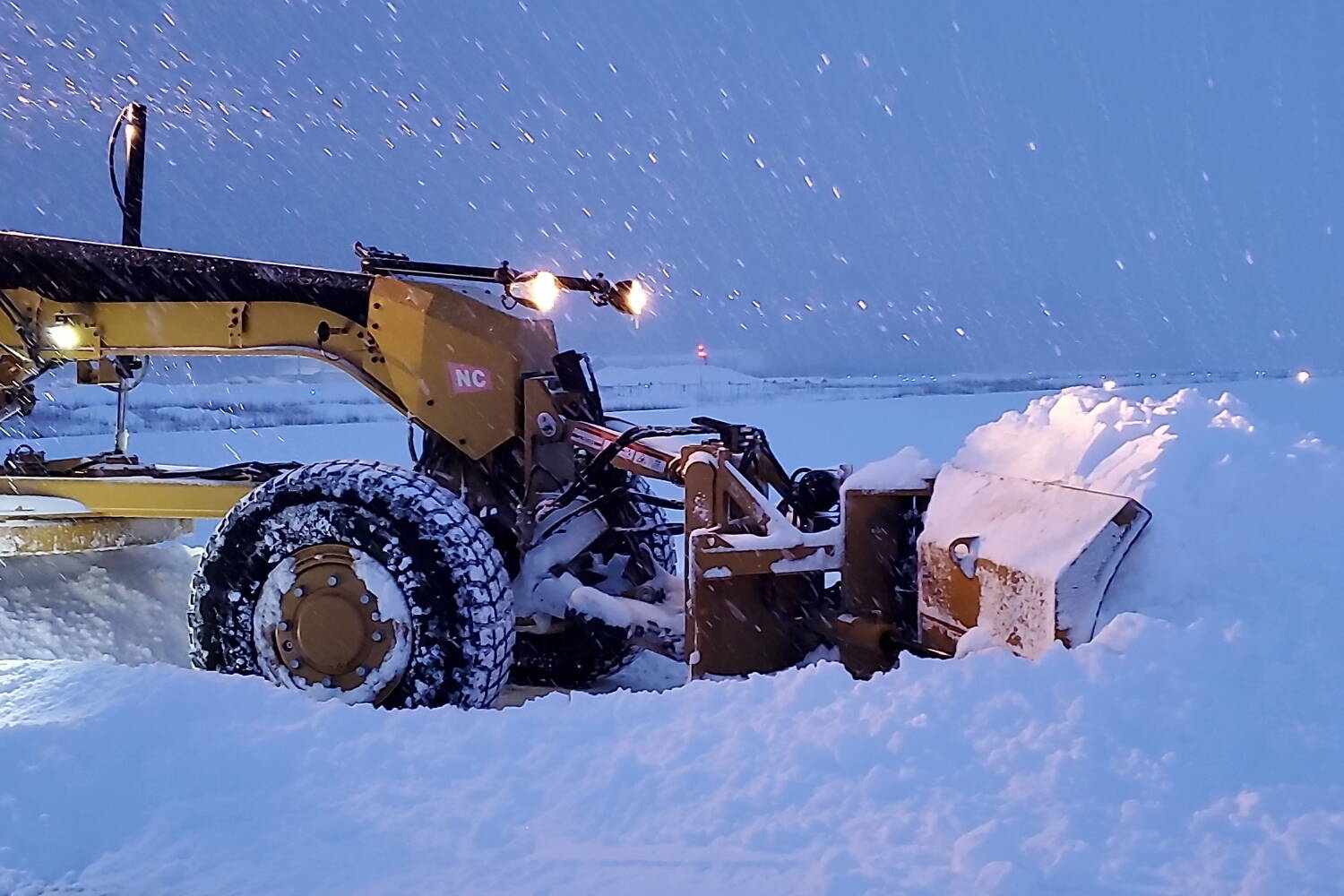 A state Department of Public Transportation and Public Facilities plow clears heavy snow from a road. The department has closed Thane Road overnight Monday and Tuesday due to the high risk of avalanches. (Alaska Department of Public Transportation and Public Facilities photo)