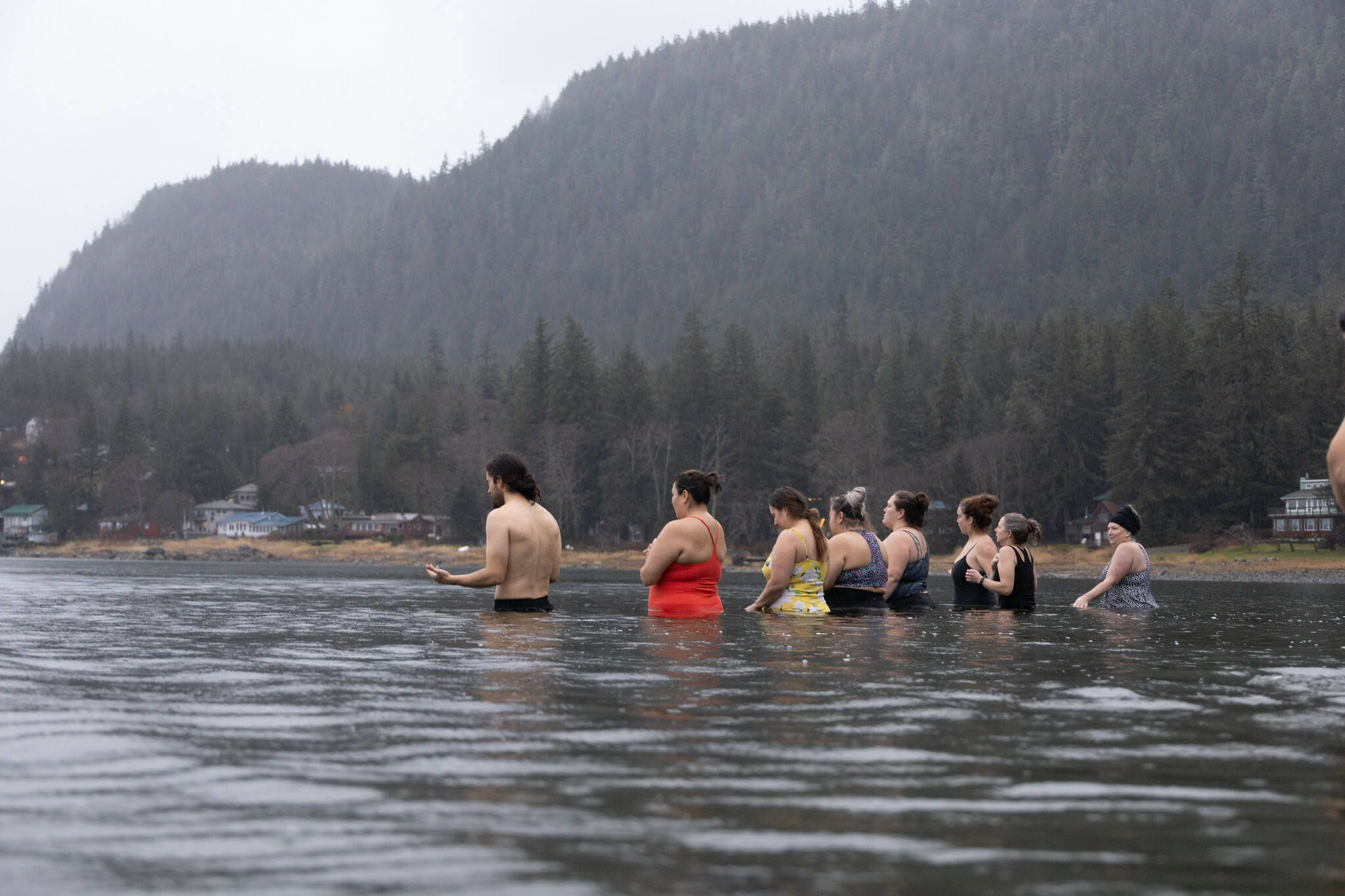 Participants in an HTL-coordinated autumn ocean dip steady themselves. Hasselquist describes how these cold water dips help cultivate community and togetherness. (Photo by Ḵaa Yahaayí Shkalneegi Muriel Reid)