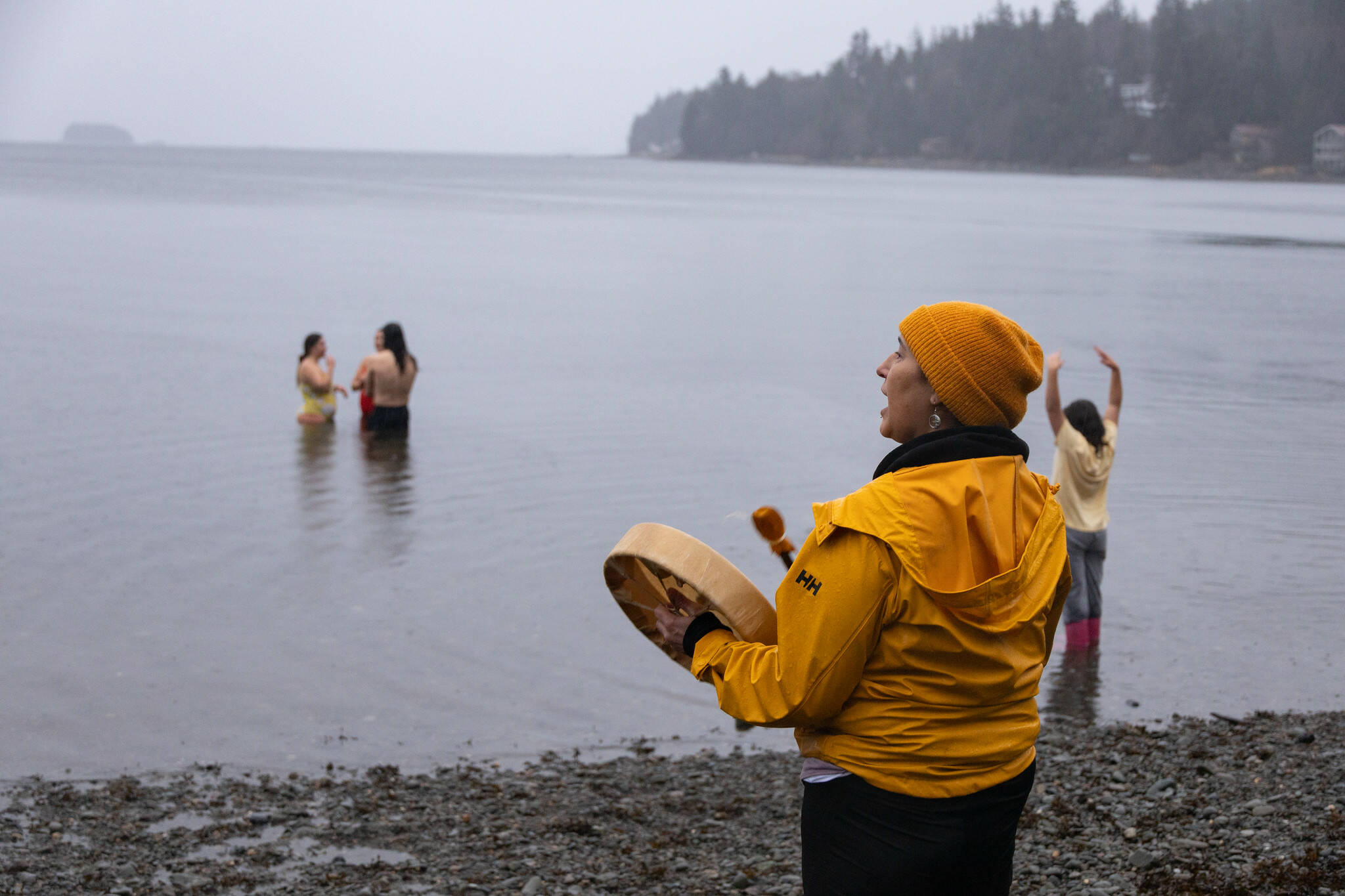 Jamiann Hasselquist drums for participants in an autumn HTL-coordinated cold water dip. The process of submerging in cold water is a cultural tradition that dates back thousands of years within Southeast Alaska– promoting strength in body and mind. (Photo by Ḵaa Yahaayí Shkalneegi Muriel Reid)