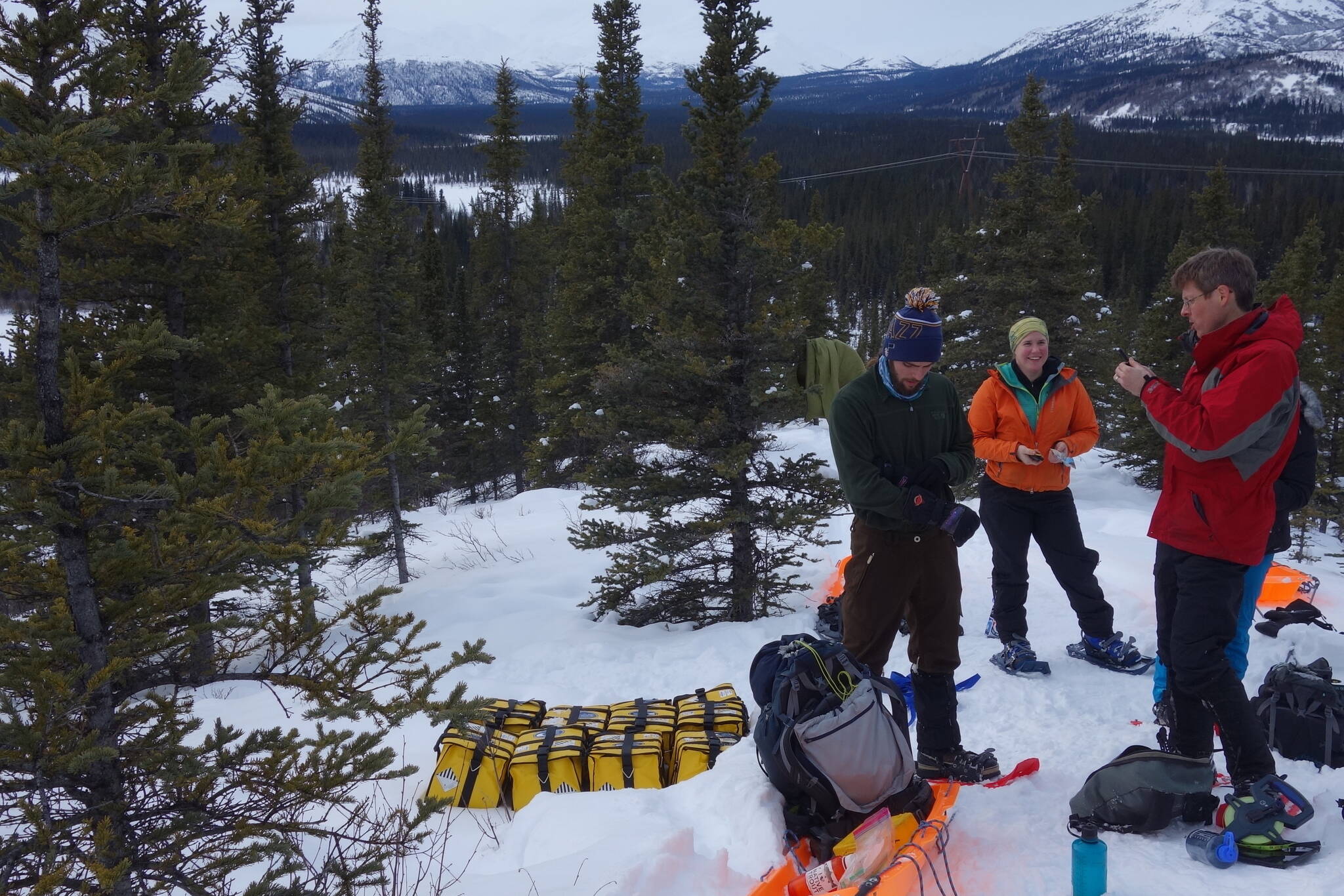 From left, Cole Richards, Lynn Kaluzienski and Carl Tape prepare to stick seismometers in frozen ground during a February 2019 mission to deploy instruments along the Denali seismic fault. The instruments helped scientists recently find the presence of a body of molten rock seven miles deep. (Photo by Ned Rozell)