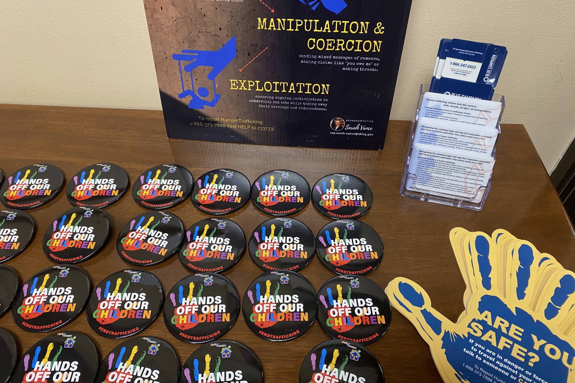 Educational materials about human trafficking filled a table outside of a Capitol room where human rights advocates spoke to lawmakers about how human trafficking affects Alaska on Jan. 24. (Photo by Claire Stremple/Alaska Beacon)