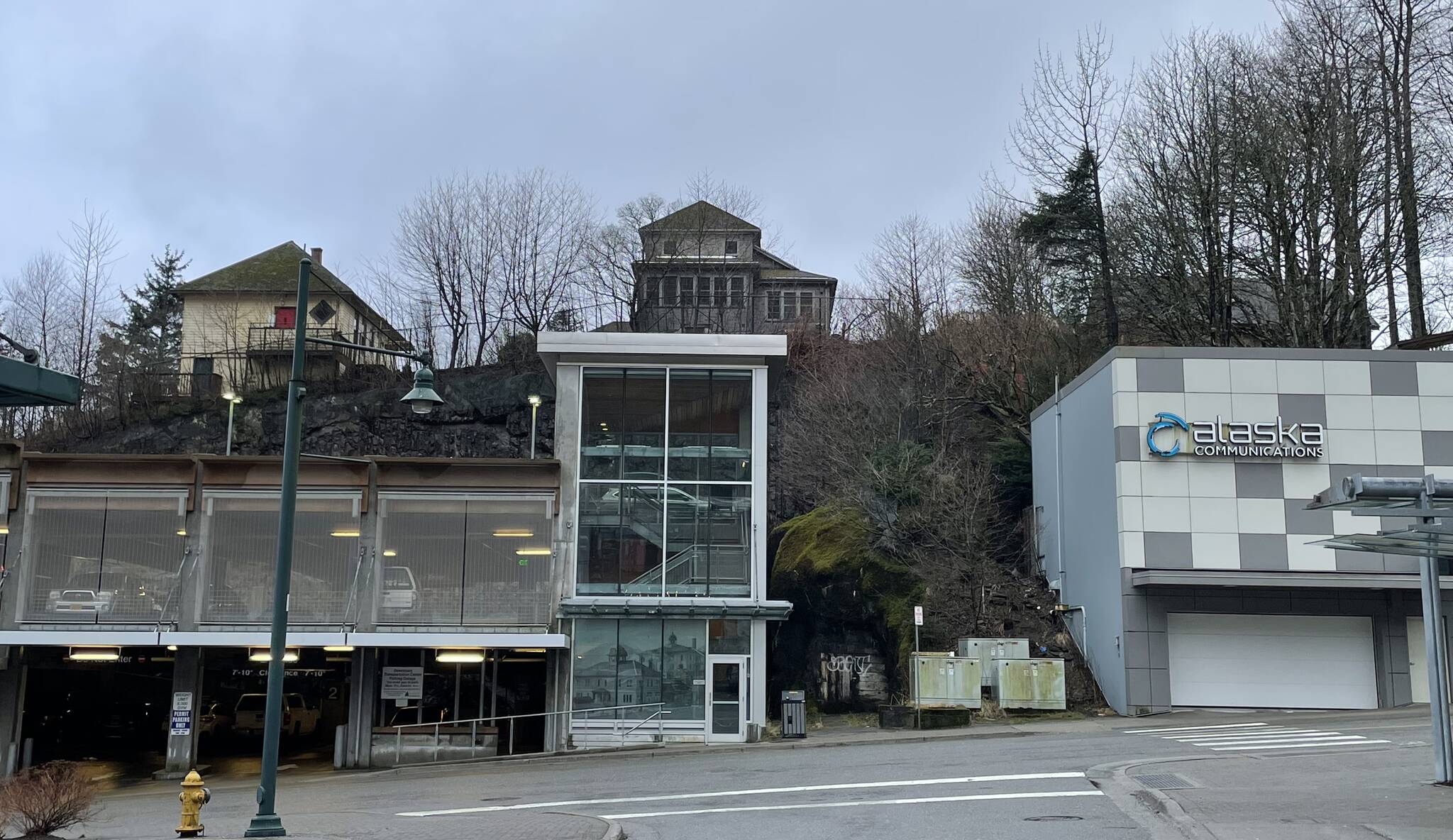 Looking up at the 1882 Edward Webster House on Telephone Hill from Second Street and Main Street in January 2024. Webster’s early telephone company operated from a 1915 addition to this house and gave the hillside its name. Note the decorative historic courthouse photo in the lower level window of the parking garage and the present ACS telephone building nearby. (Photo by Laurie Craig)