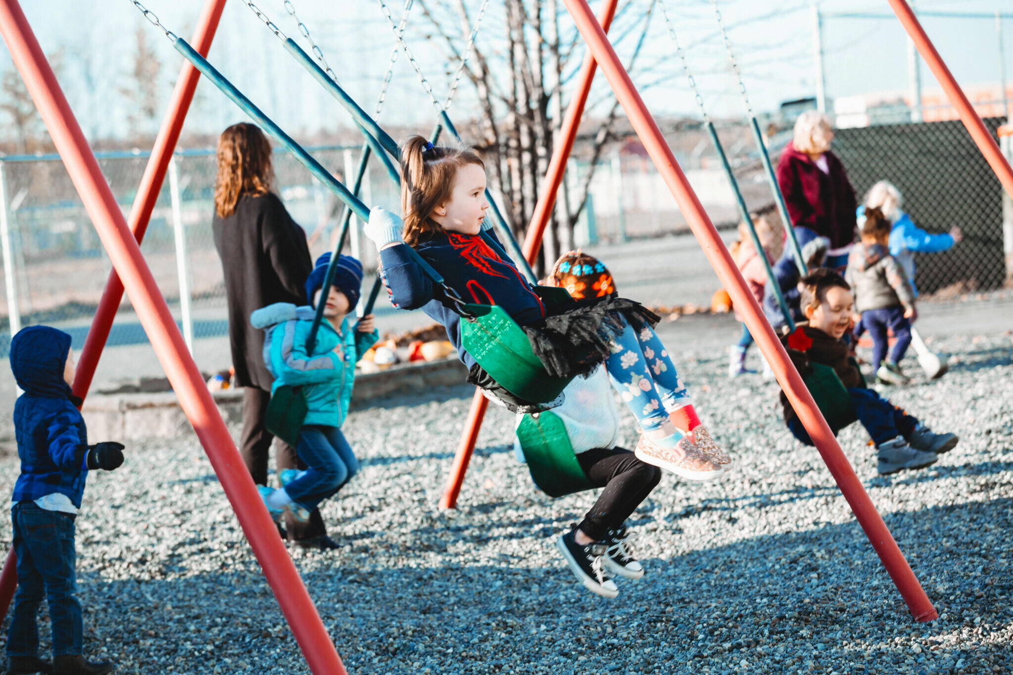 Students swing on a playground at Meadow Lakes Head Start in Wasilla. (Image by Lela Seiler, courtesy of CCS Early Learning)