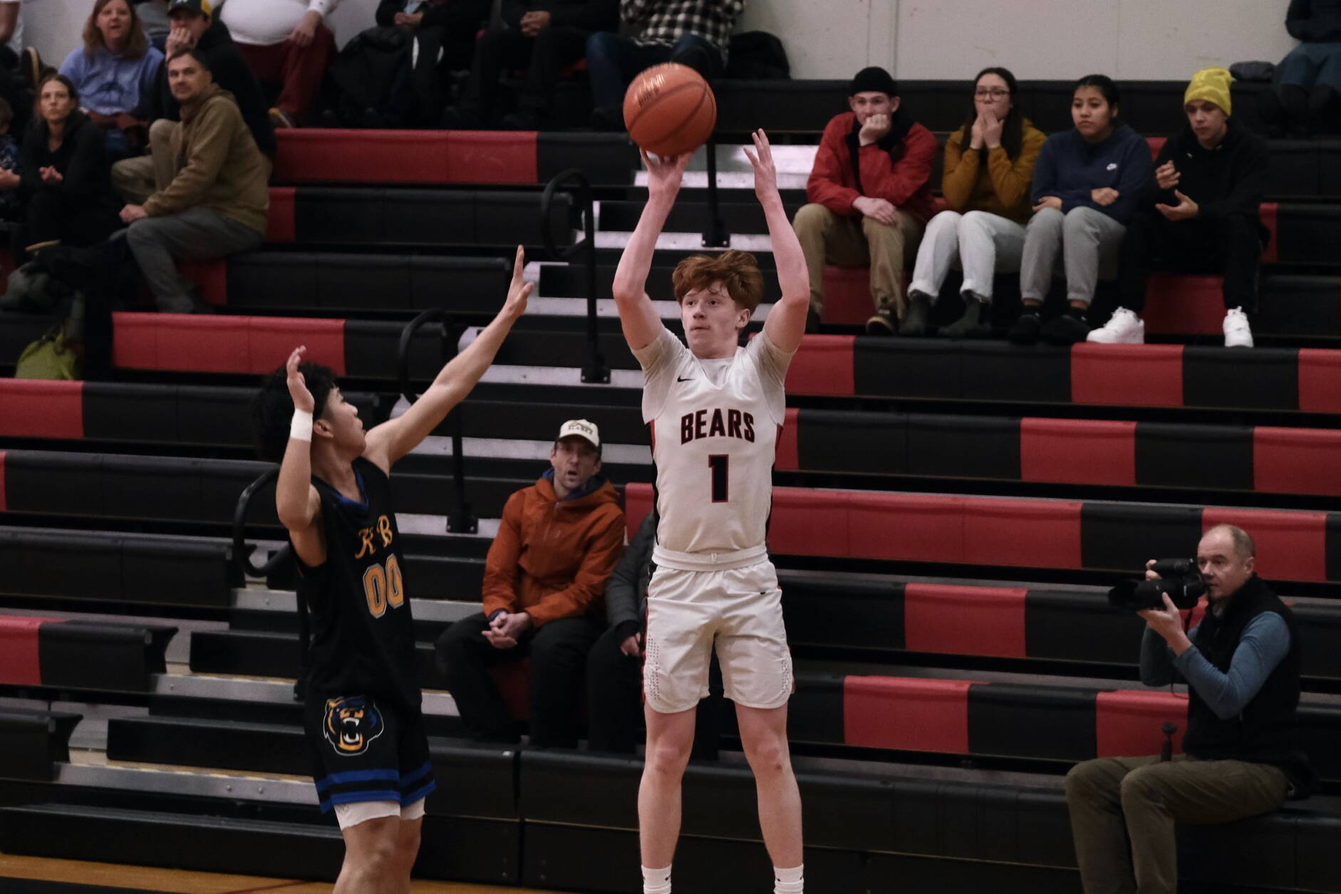 Juneau-Douglas High School: Yadaa.at Kalé junior Gavin Gerrin (1) scores from past the arc over Kodiak junior Mac Abellera (00) during the Crimson Bears 75-50 win over the Bears on Saturday at the George Houston Gymnasium. (Klas Stolpe/For the Juneau Empire)