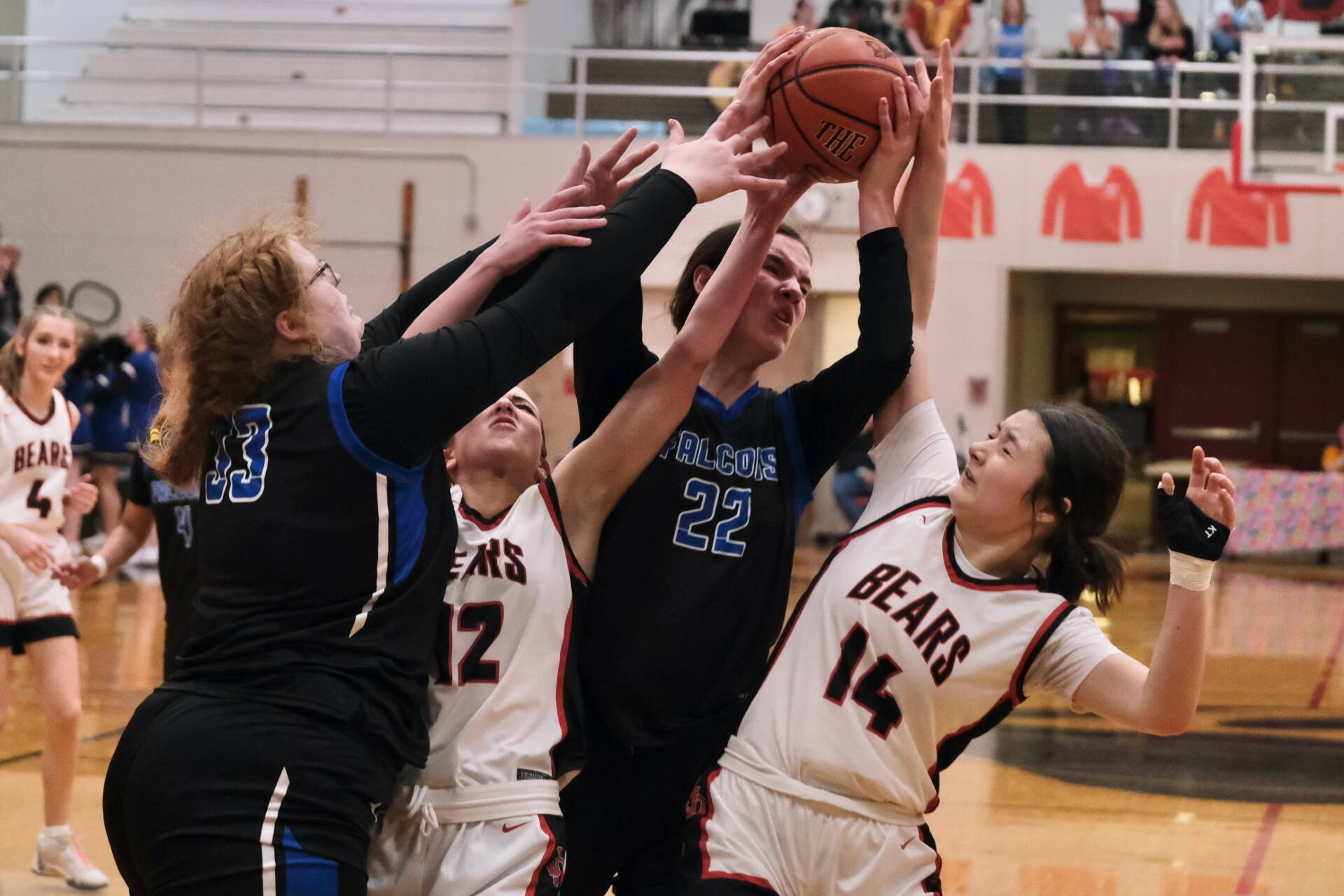 Thunder Mountain High School senior Kara Strong, Juneau-Douglas High School: Yadaa.at Kalé junior Nadia Wilson (12), TMHS junior Kerra Baxter (22) and JDHS freshman Layla Tokuoka (14) battle for a rebound during the Falcons 42-28 win over the Crimson Bears on Saturday at the George Houston Gymnasium. (Klas Stolpe/For the Juneau Empire)
