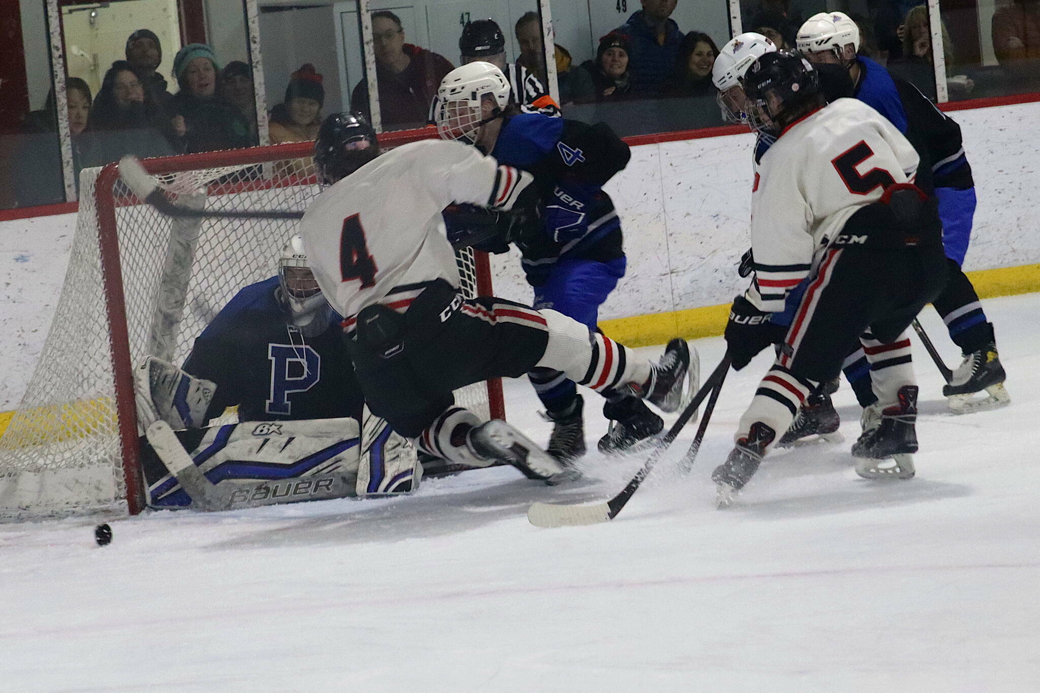 Juneau-Douglas High School: Yadaa.at Kalés Caden Johns (#5), seen here in a Dec. 16, 2023, game against Palmer High School, was the lone JDHS player named to the all-tournament team during the Division II state hockey tournament in that concluded Saturday in Soldotna. Luke Bovitz (#4) was one of two key players missing during the tournament due to injuries. The Crimson Bears finished fourth in the tournament. (Mark Sabbatini / Juneau Empire file photo)