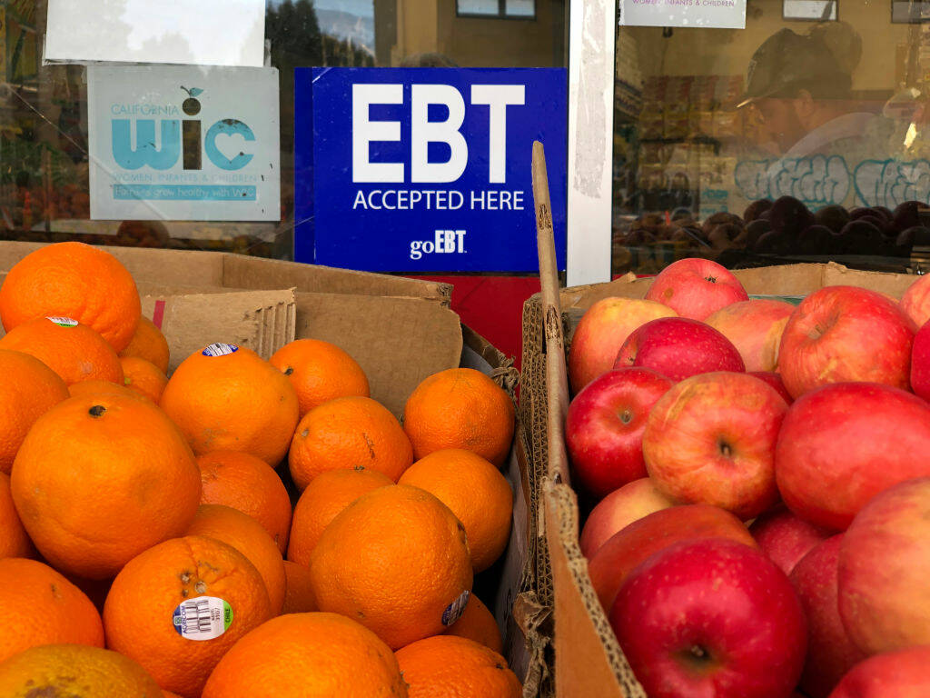A sign noting the acceptance of electronic benefit transfer (EBT) cards that are used by state welfare departments to issue benefits is displayed at a grocery store on Dec. 4, 2019, in Oakland, California. (Photo by Justin Sullivan/Getty Images)