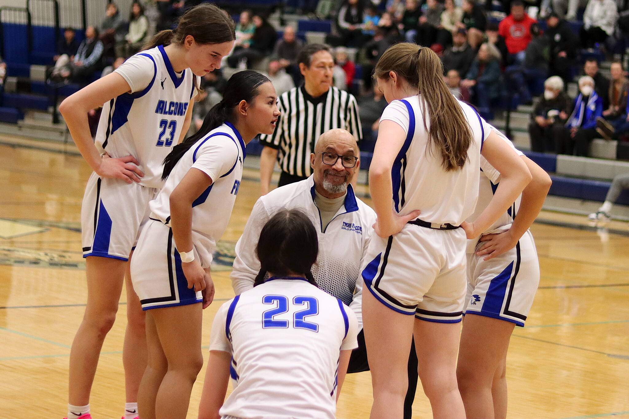Thunder Mountain High School Head Coach Andy Lee confers with his players during a timeout in Saturday’s game against Ketchikan High School at TMHS. (Mark Sabbatini / Juneau Empire)