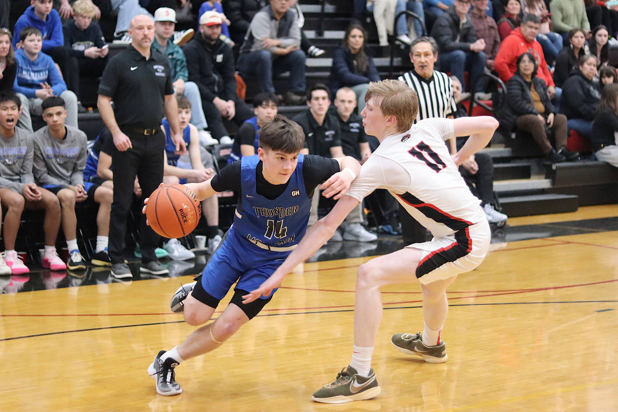 Samuel Lockhart (#14) of Thunder Mountain High School tries to get past Sean Oliver of Juneau-Douglas High School: Yadaa.at Kalé during Wednesday night’s game at JDHS. (Mark Sabbatini / Juneau Empire)
