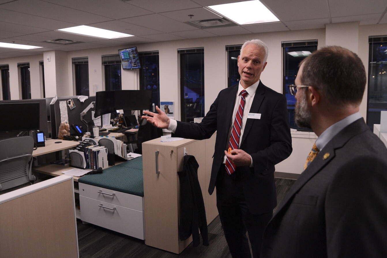 Deven Mitchell, executive director of the Alaska Permanent Fund Corp., gives a tour of the corporation’s investment floor to Sen. Jesse Kiehl, D-Juneau, and other attendees of an open house on Friday. (James Brooks/Alaska Beacon)
