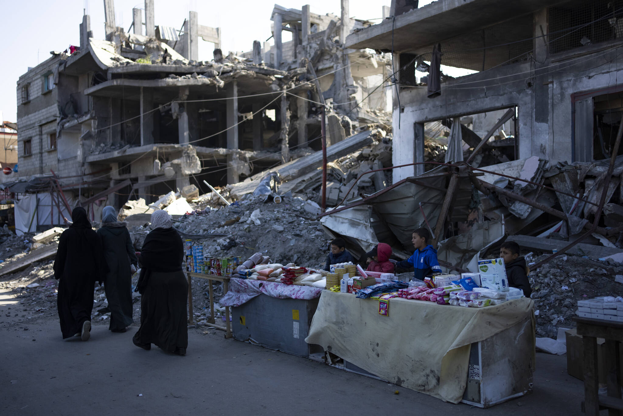 Palestinians sell goods next to buildings destroyed by an Israeli airstrike in Rafah, Gaza Strip, Wednesday, Feb. 21, 2024. An estimated 1.5 million Palestinians displaced by the war took refuge in Rafahor, which is likely Israel’s next focus in its war against Hamas. (AP Photo/Fatima Shbair)
