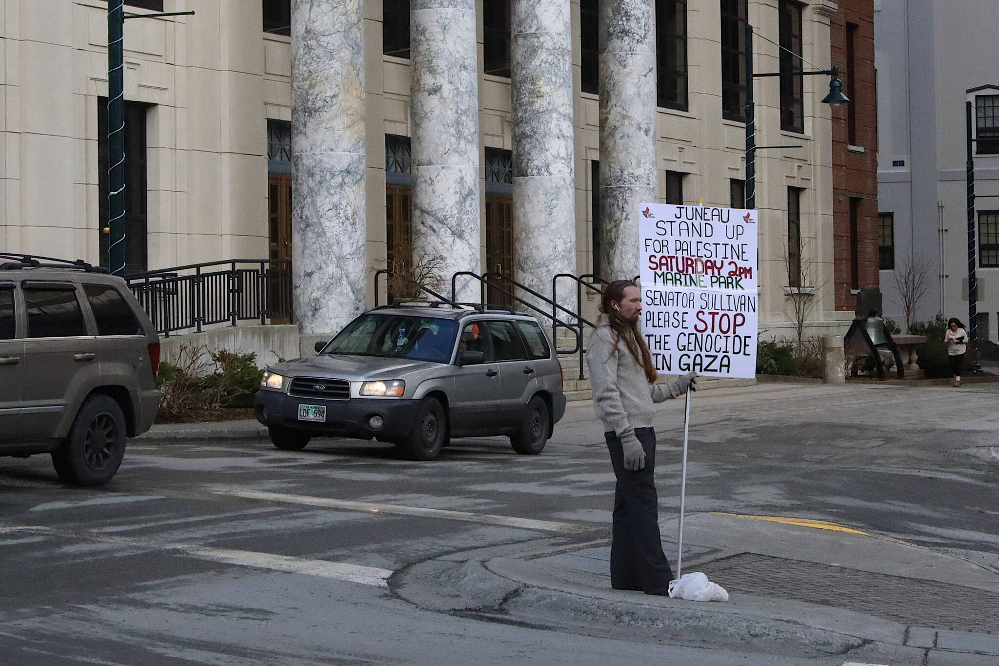 Eric Bookless holds up a protest sign regarding the situation in Gaza while standing in a traffic median next to the Alaska State Capitol on Wednesday. Gov. Mike Dunleavy introduced a bill during the day that would increase the penalties and definitions of illegal protests, although Bookless’ actions do not appear to fall under its provisions. (Mark Sabbatini / Juneau Empire)