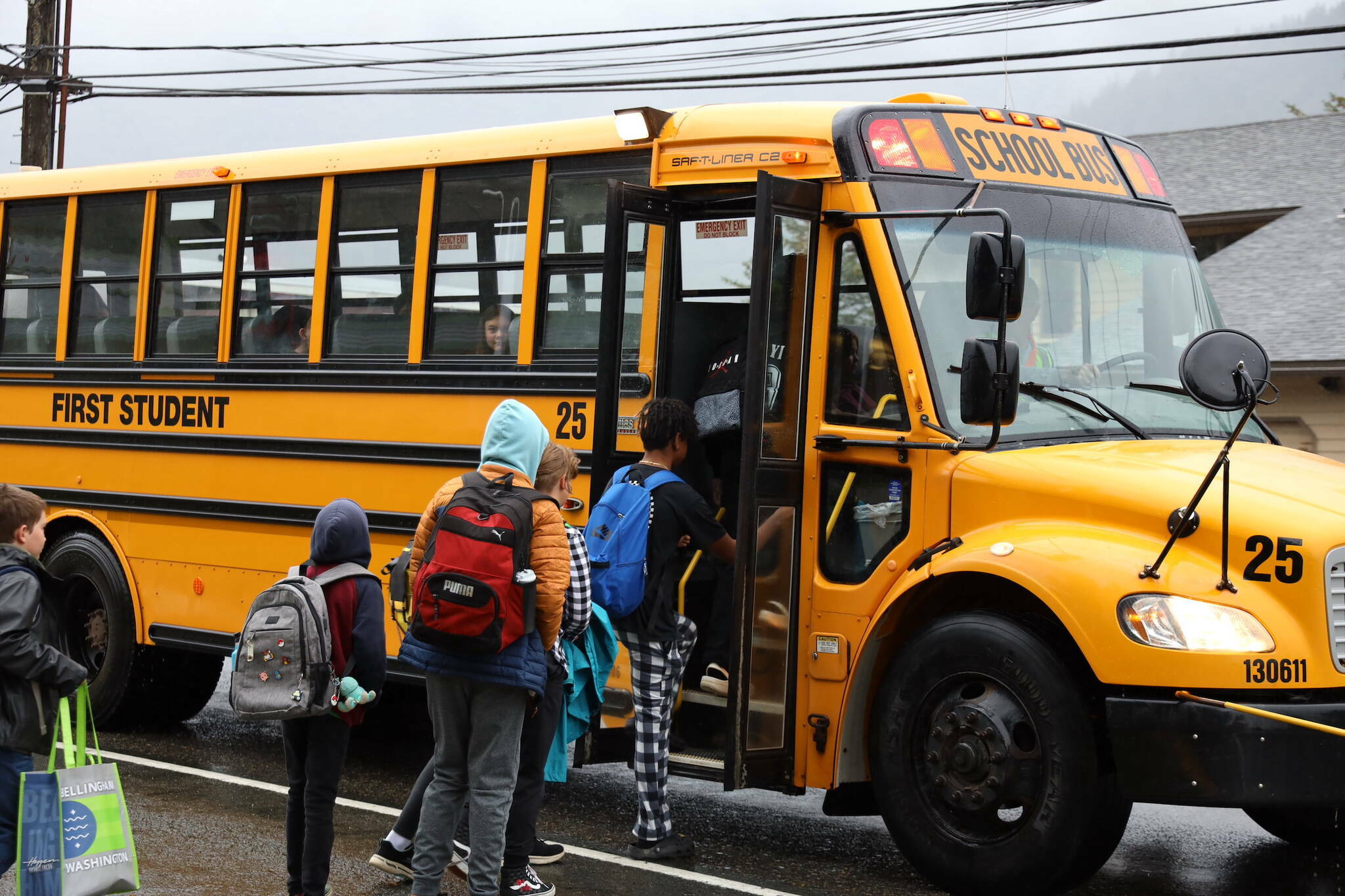 Students enter a bus stopped on Douglas Highway during the first day of the 2023-2024 school year. (Clarise Larson / Juneau Empire file photo)