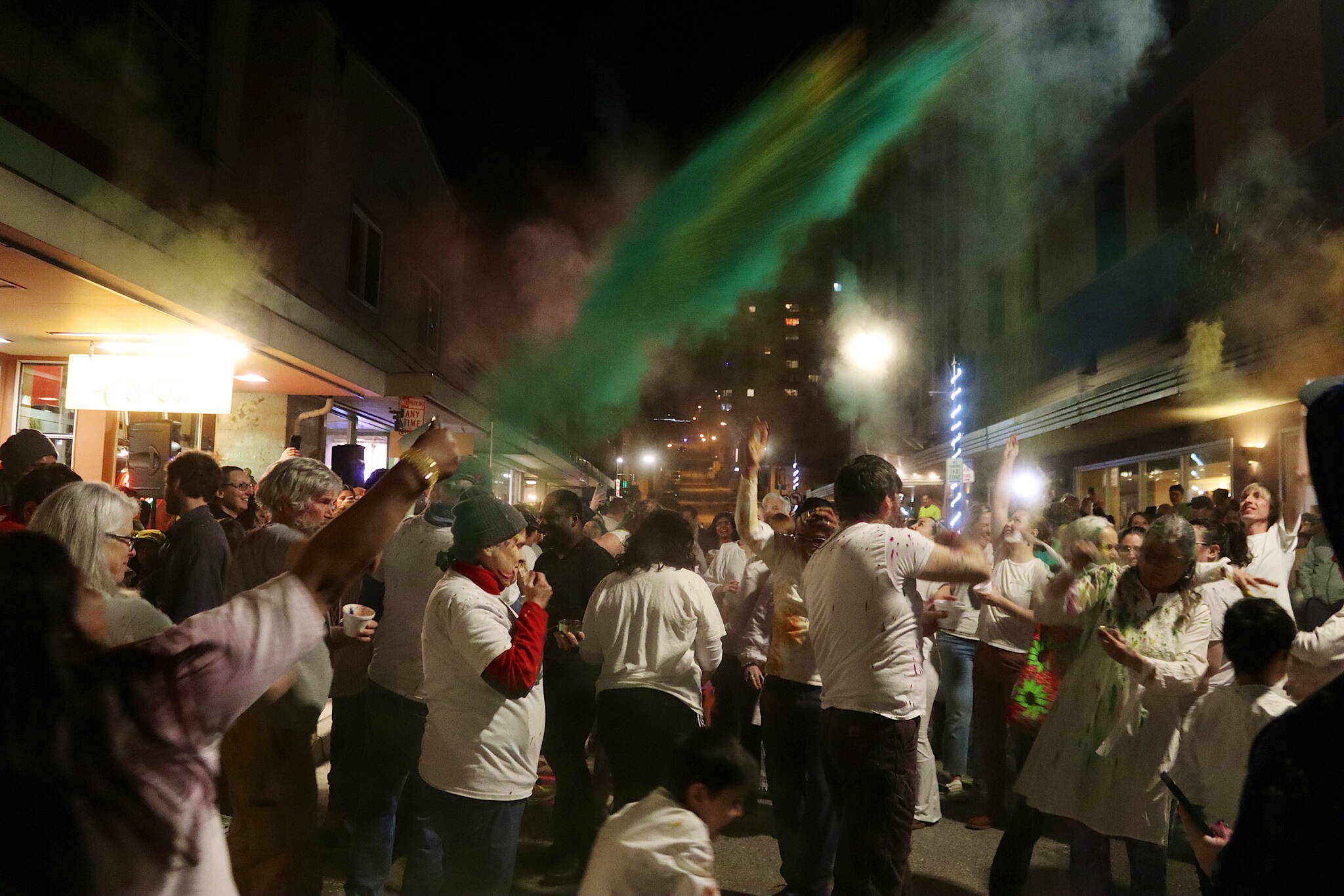 Dozens of people throw colors in the air and at each other during a Holi festival gathering Monday night outside Spice Juneau Indian Cuisine. (Mark Sabbatini / Juneau Empire)