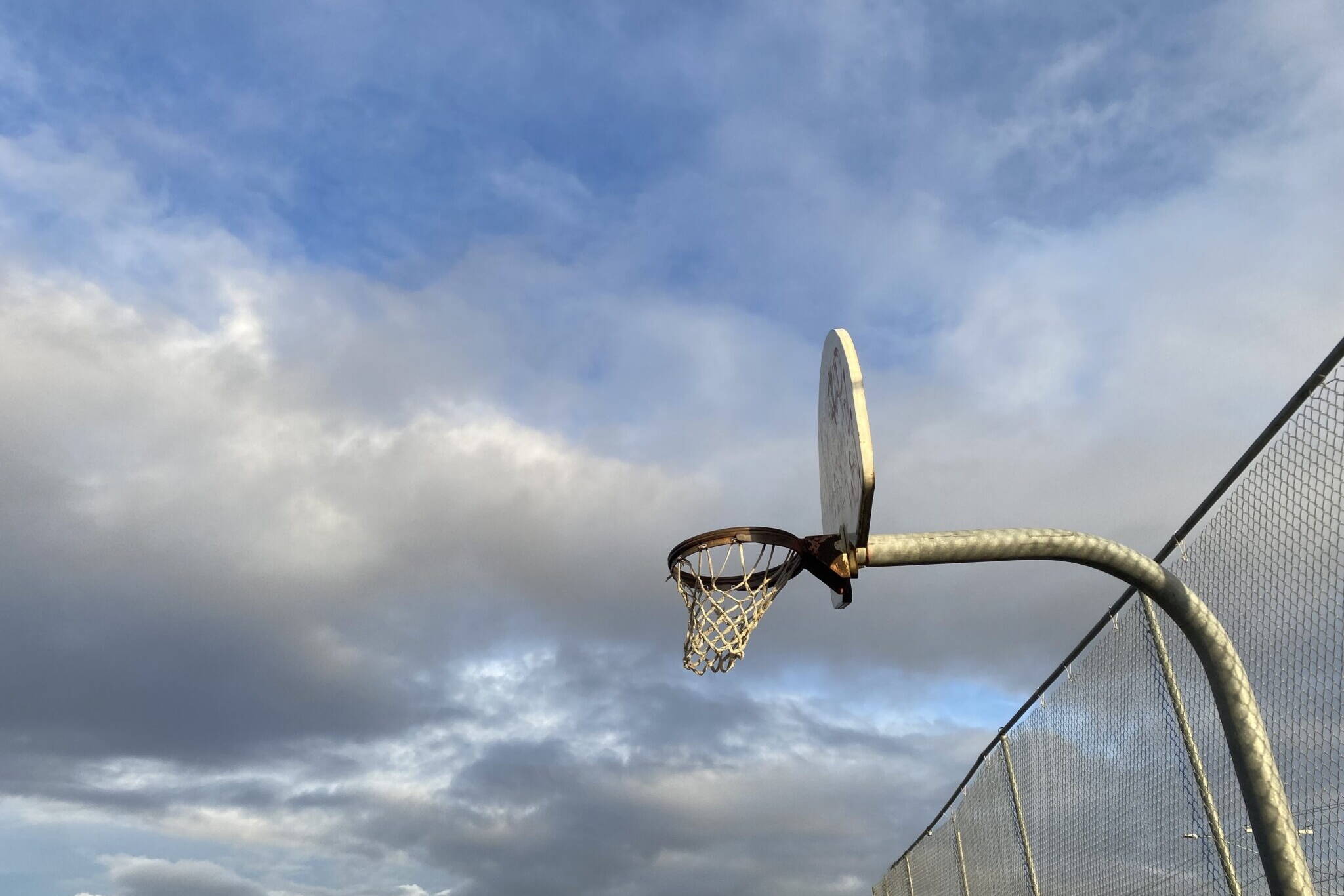 An outdoor basketball hoop is seen in Bethel in October 2022. A bill advanced in the House Education Committee on Wednesday would expand limitations for trans girls on sports teams. (Claire Stremple / Alaska Beacon)
