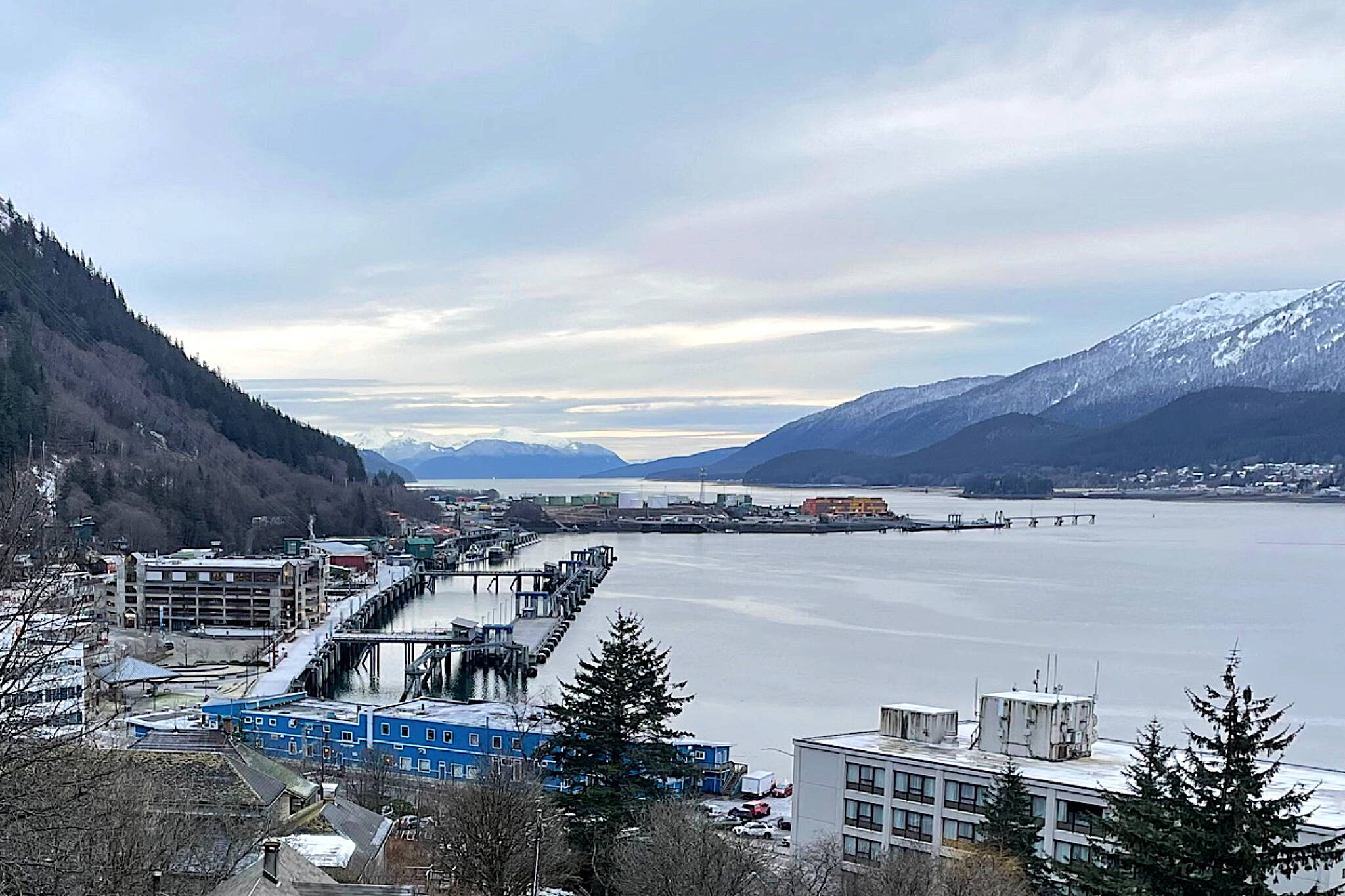 Looking south from downtown Juneau in December 2023 with buildings and docks in the foreground, the rock dump can be seen jutting into Gastineau Channel and providing a weather-protected harbor for Juneau. (Photo by Laurie Craig)