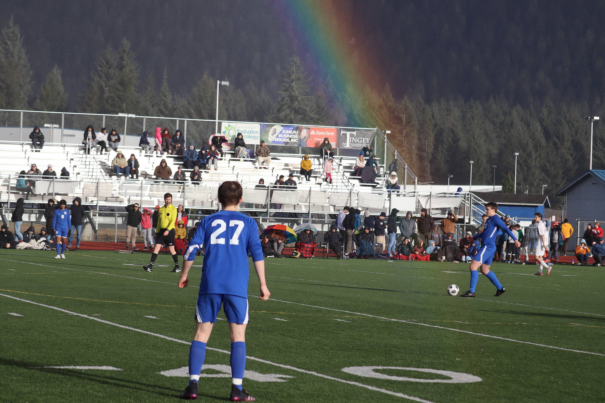 A rainbow connects with Kajson Cunningham (30) as he connects with the ball for Thunder Mountain High School during Tuesday’s game against Juneau-Douglas High School: Yadaa.at Kalé at JDHS, the opening match of the season for both teams. (Mark Sabbatini / Juneau Empire)