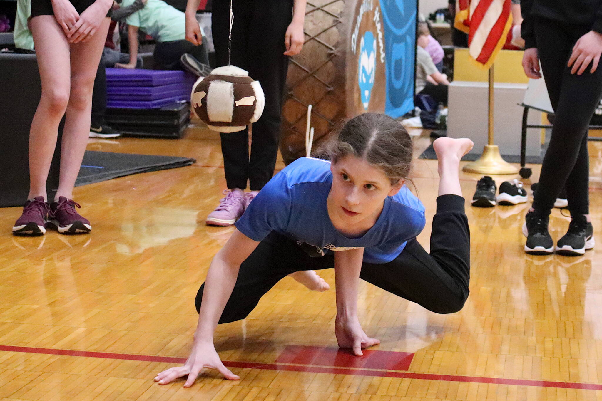 Maddy Fortunato, a Chickaloon middle school student, sets to attempt the one-hand reach by touching a suspended ball while remaining balanced on the other hand during the Traditional Games on Sunday at Juneau-Douglas High School: Yadaa.at Kalé. (Mark Sabbatini / Juneau Empire)