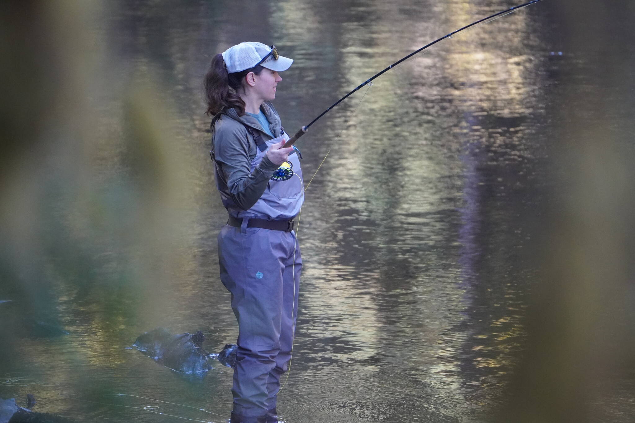 The author’s wife fights a steelhead while the author contemplates fly selection. (Photo by Jeff Lund)